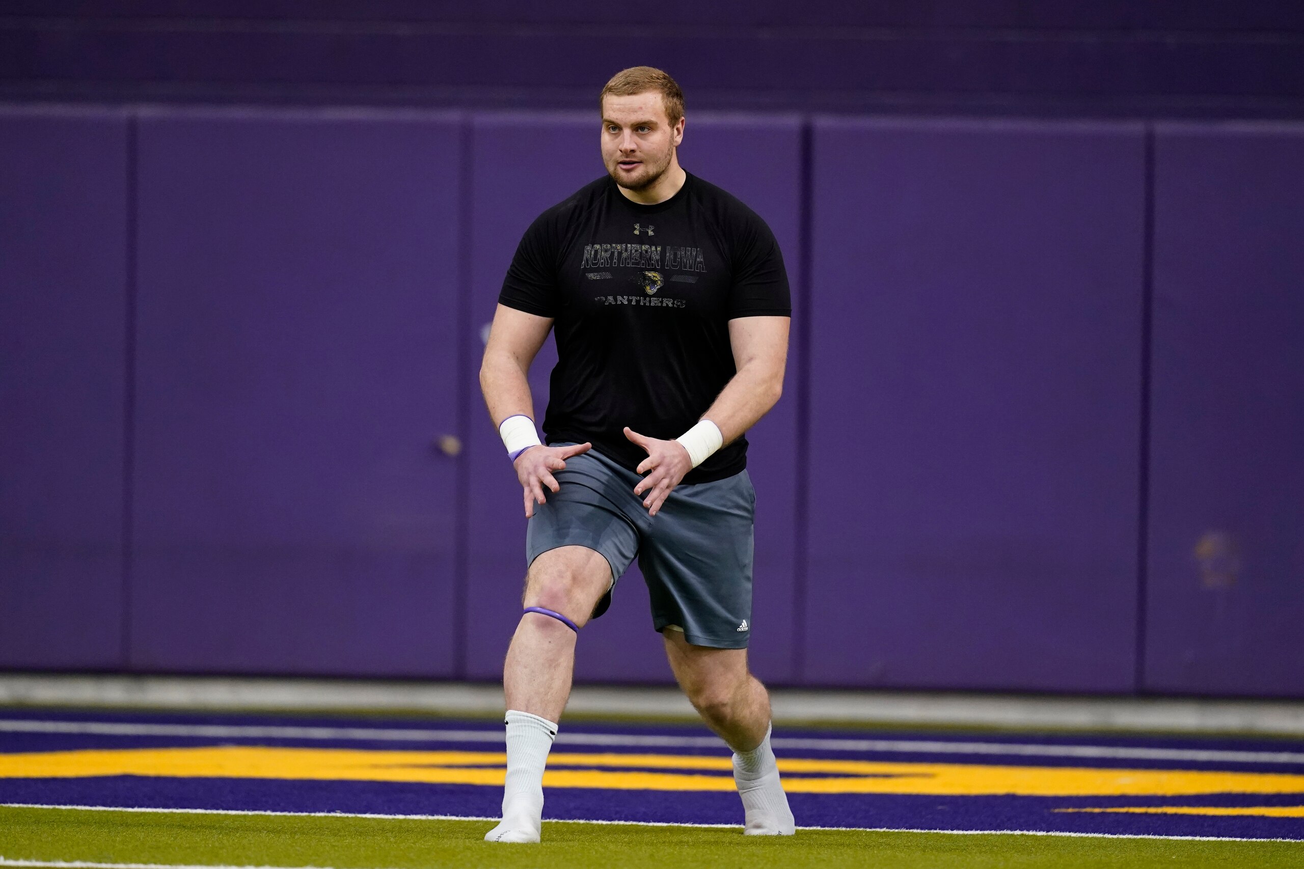 Northern Iowa offensive lineman Trevor Penning stretches before a drill at an NCAA college football pro day, Monday, March 21, 2022, in Cedar Falls, Iowa. (AP Photo/Charlie Neibergall)