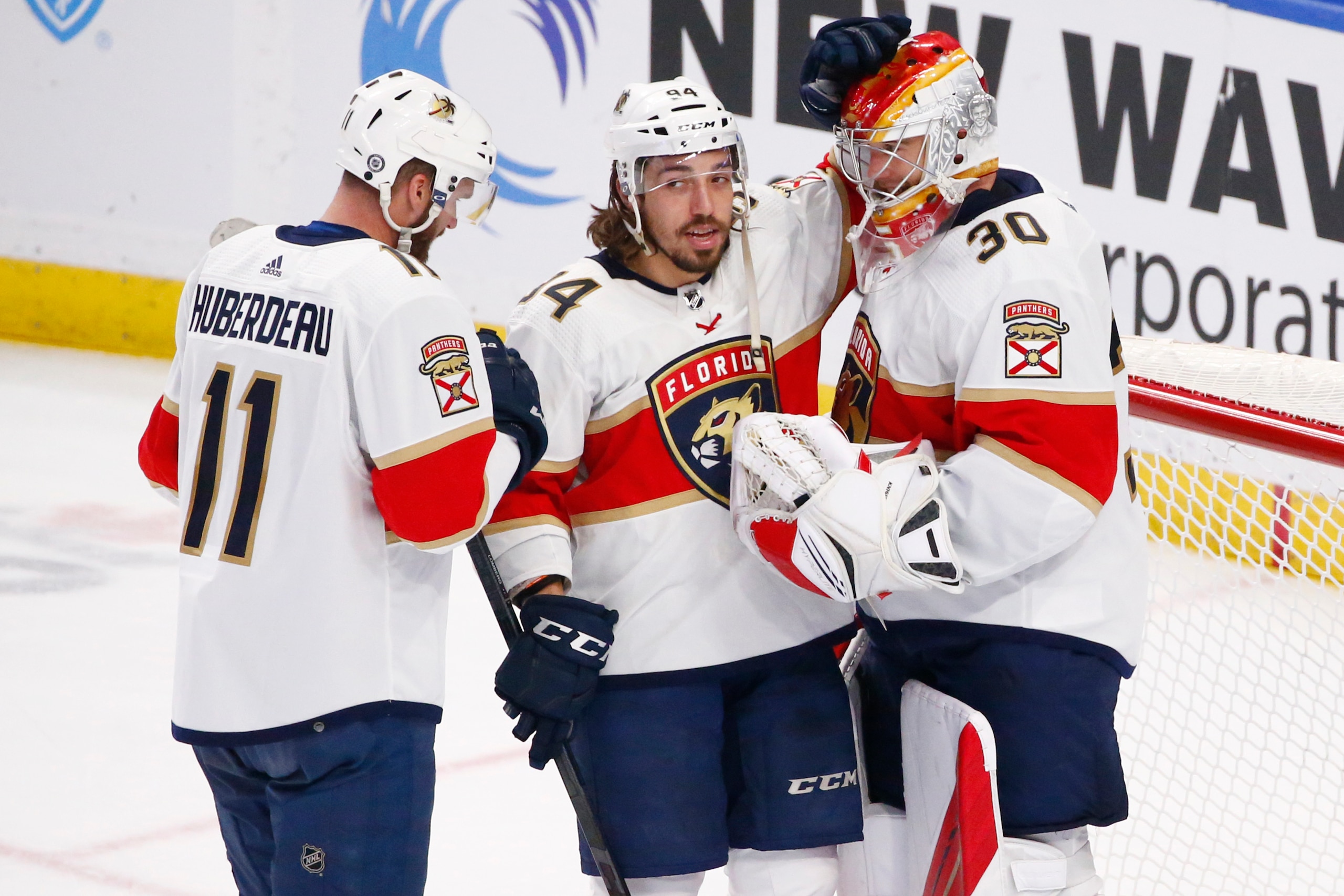 Florida Panthers left wing Jonathan Huberdeau (11) and left wing Ryan Lomberg (94) celebrate a victory with goaltender Spencer Knight (30) following the third period of an NHL hockey game against the Buffalo Sabres, Sunday, April 3, 2022, in Buffalo, N.Y. (AP Photo/Jeffrey T. Barnes)