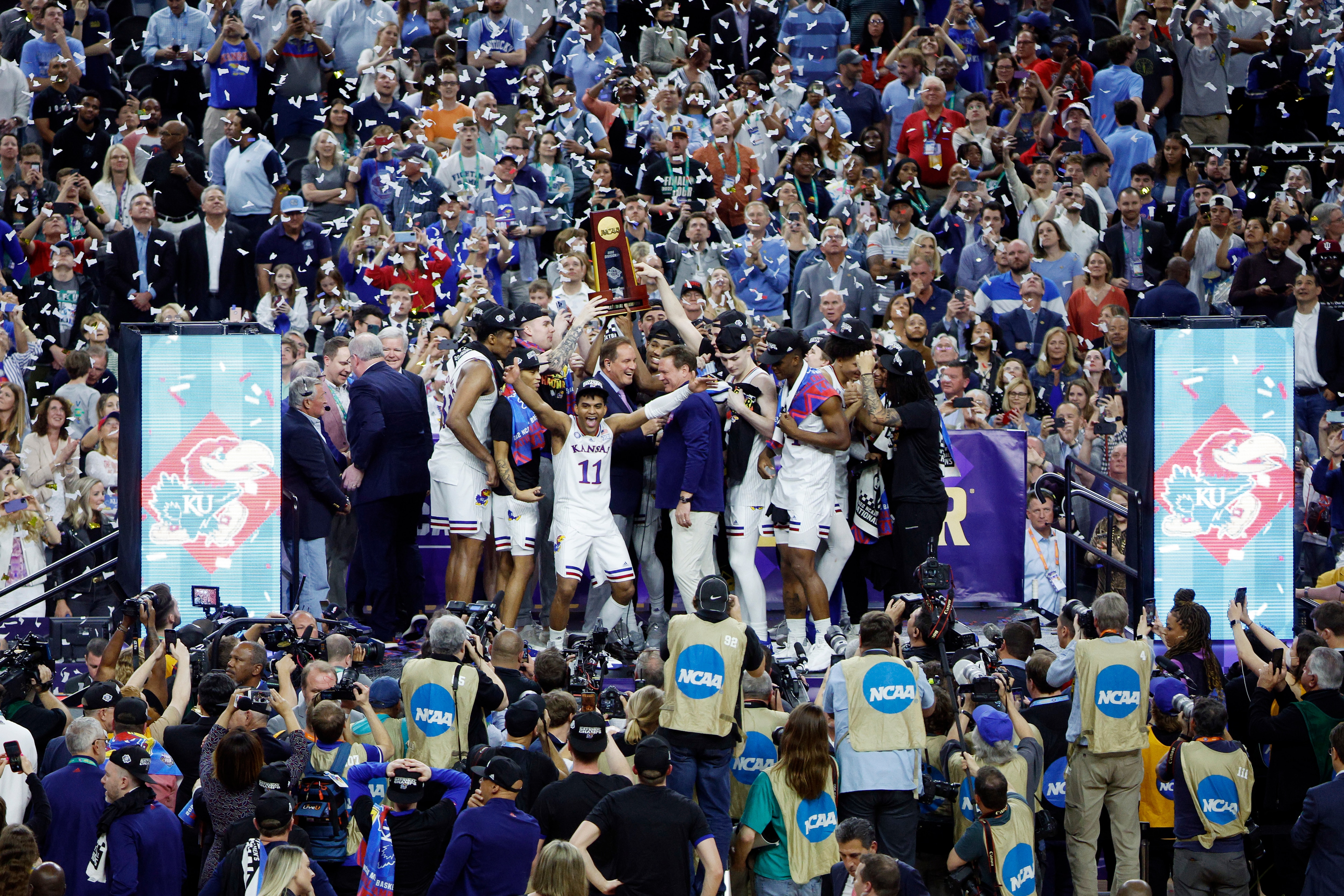 NEW ORLEANS, LOUISIANA - APRIL 04: Kansas Jayhawks players and coaches hold up the trophy after defeating the North Carolina Tar Heels 72-69 during the 2022 NCAA Men's Basketball Tournament National Championship at Caesars Superdome on April 04, 2022 in New Orleans, Louisiana. (Photo by Chris Graythen/Getty Images)