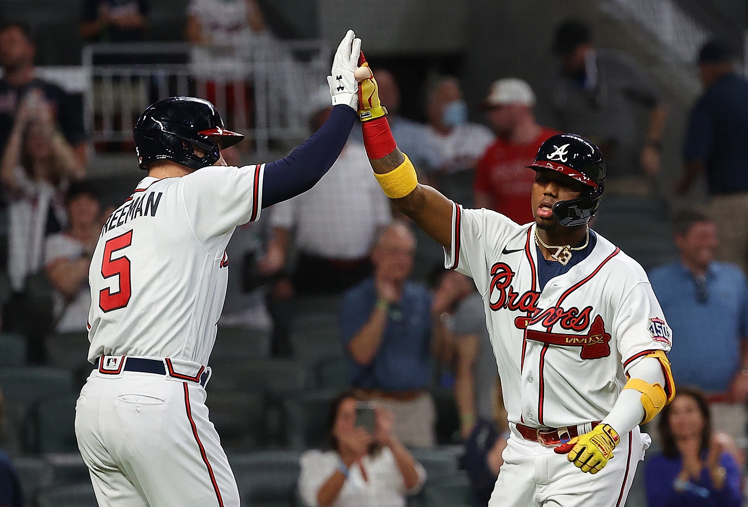 ATLANTA, GEORGIA - APRIL 27:  Ronald Acuna Jr. #13 of the Atlanta Braves reacts with Freddie Freeman #5 after hitting a solo homer in the fifth inning against the Chicago Cubs at Truist Park on April 27, 2021 in Atlanta, Georgia. (Photo by Kevin C. Cox/Getty Images)