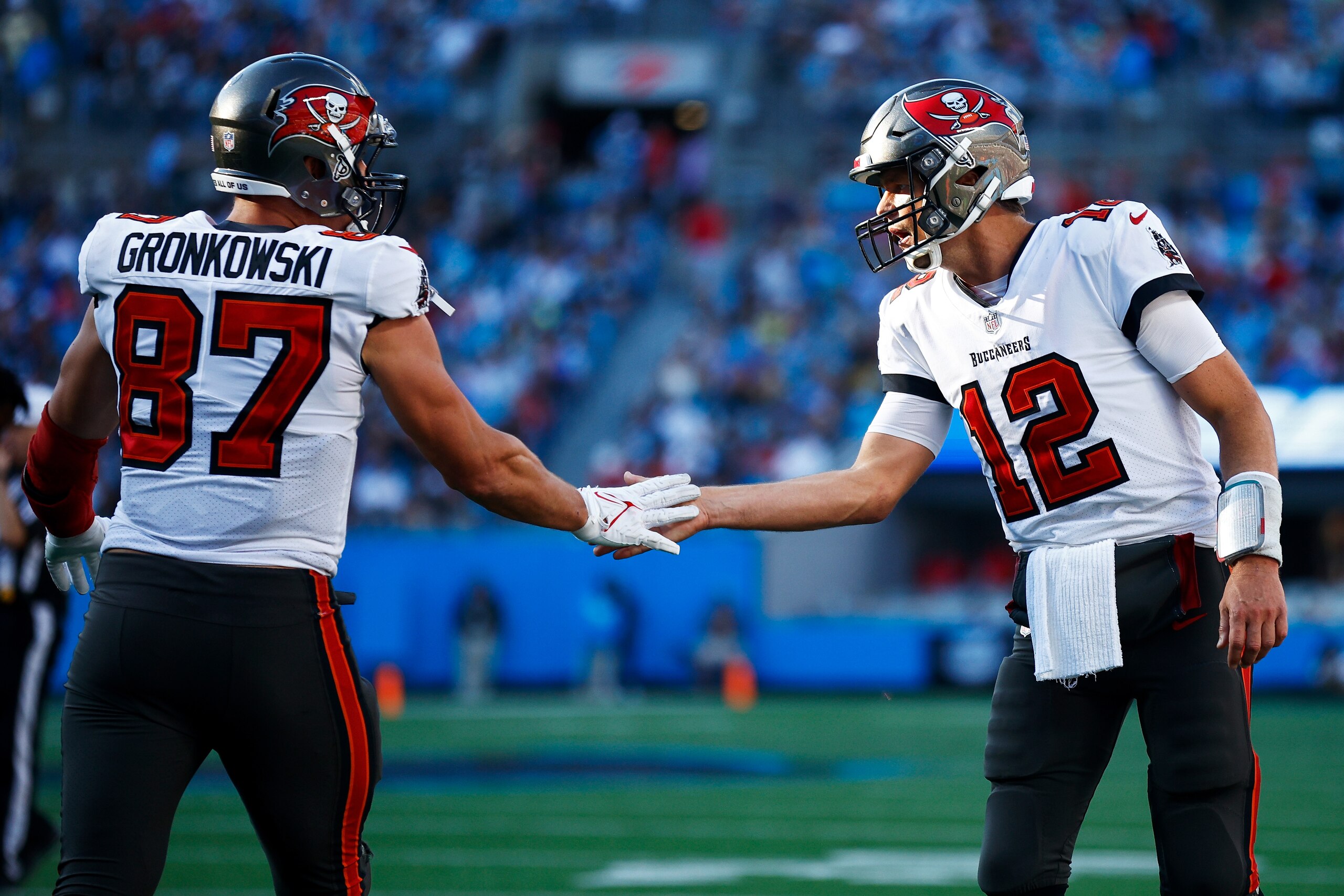 CHARLOTTE, NORTH CAROLINA - DECEMBER 26: Tom Brady #12 and Rob Gronkowski #87 of the Tampa Bay Buccaneers react after a touchdown during the third quarter in the game against the Carolina Panthers at Bank of America Stadium on December 26, 2021 in Charlotte, North Carolina. (Photo by Jared C. Tilton/Getty Images)