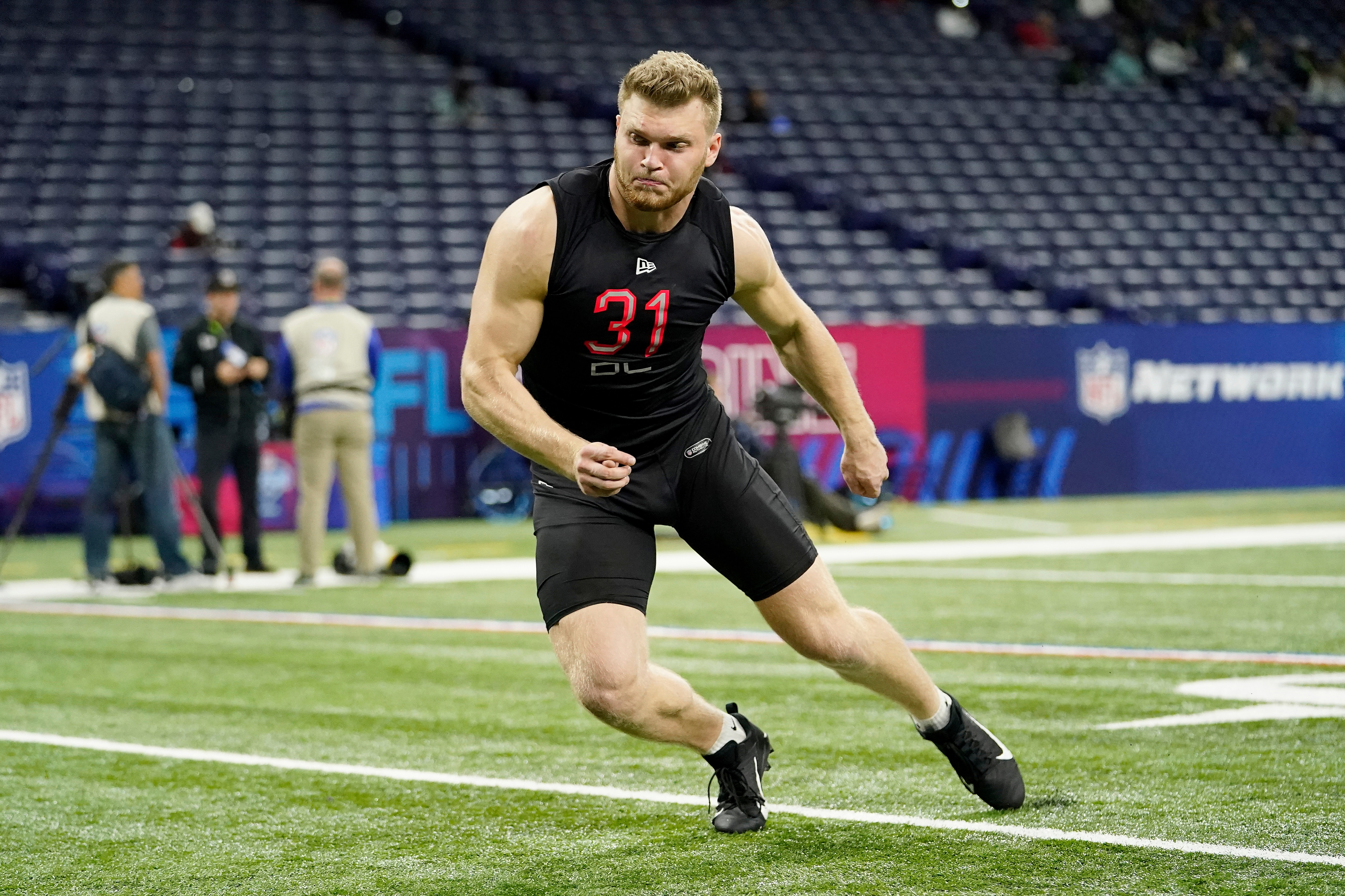 Michigan defensive lineman Aidan Hutchinson (31) participates in a drill at the NFL football scouting combine in Indianapolis, Saturday, March 5, 2022. (AP Photo/Steve Luciano)