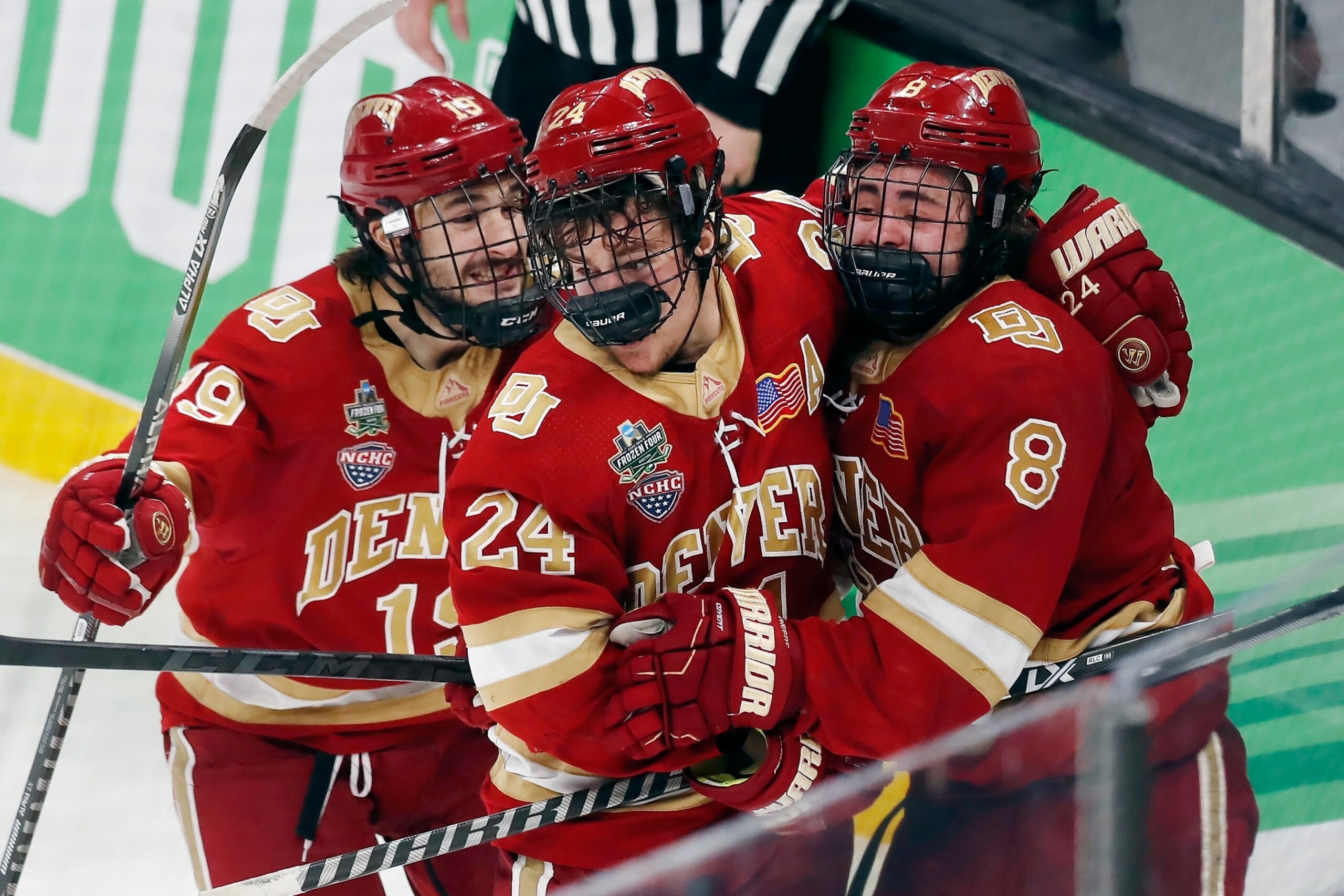 Denver's Carter Savoie (8) celebrates his winning goal with Bobby Brink (24) and Cole Guttman (19) in overtime during an NCAA men's Frozen Four semifinal hockey game against Michigan, Thursday, April 7, 2022, in Boston. (AP Photo/Michael Dwyer)