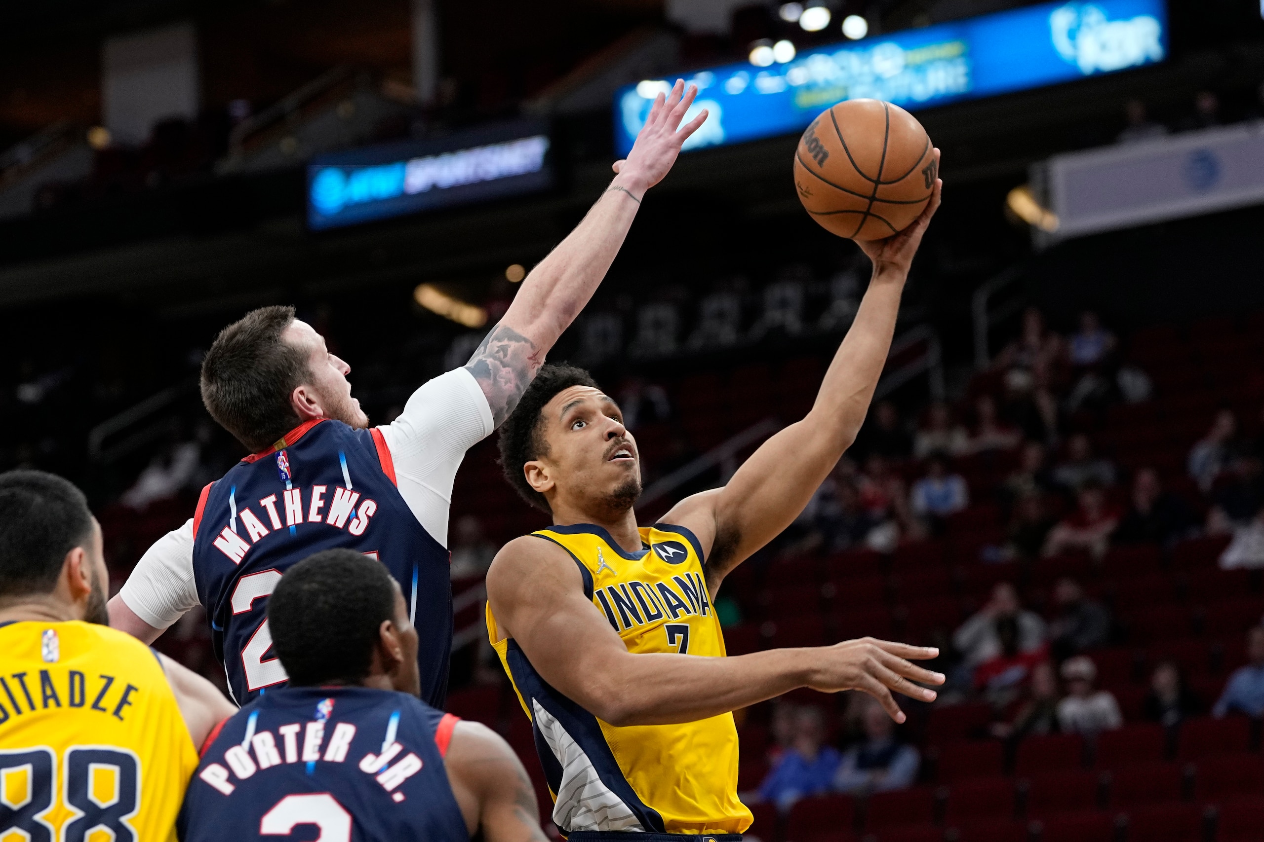 Indiana Pacers' Malcolm Brogdon (7) goes up for a shot as Houston Rockets' Garrison Mathews defend during the first half of an NBA basketball game Friday, March 18, 2022, in Houston. The Pacers won 121-118. (AP Photo/David J. Phillip)