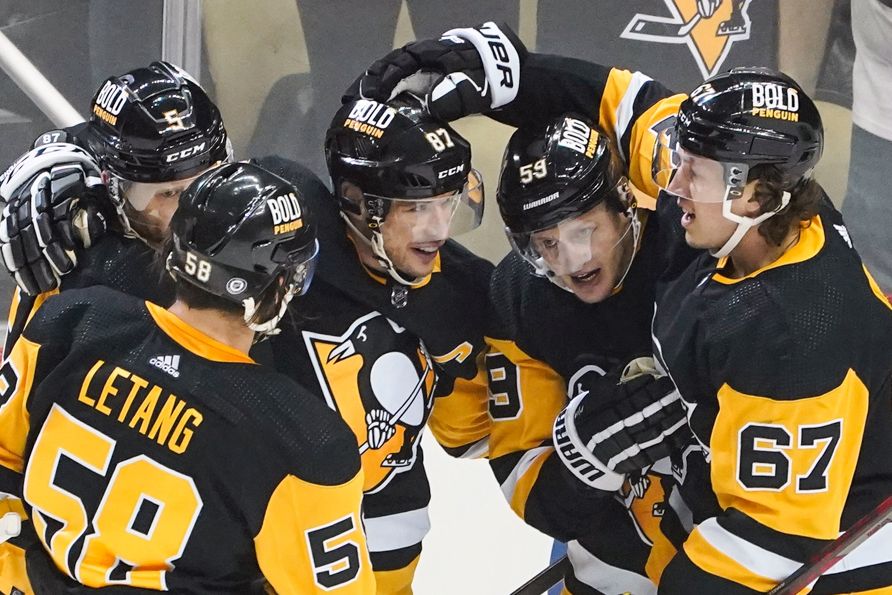 Pittsburgh Penguins' Sidney Crosby, center, is greeted by teammates Rickard Rakell (67), Jake Guentzel (59), Mike Matheson (5) and Kris Letang (58) after scoring against the Nashville Predators during the first period of an NHL hockey game, Sunday, April 10, 2022, in Pittsburgh. (AP Photo/Keith Srakocic)