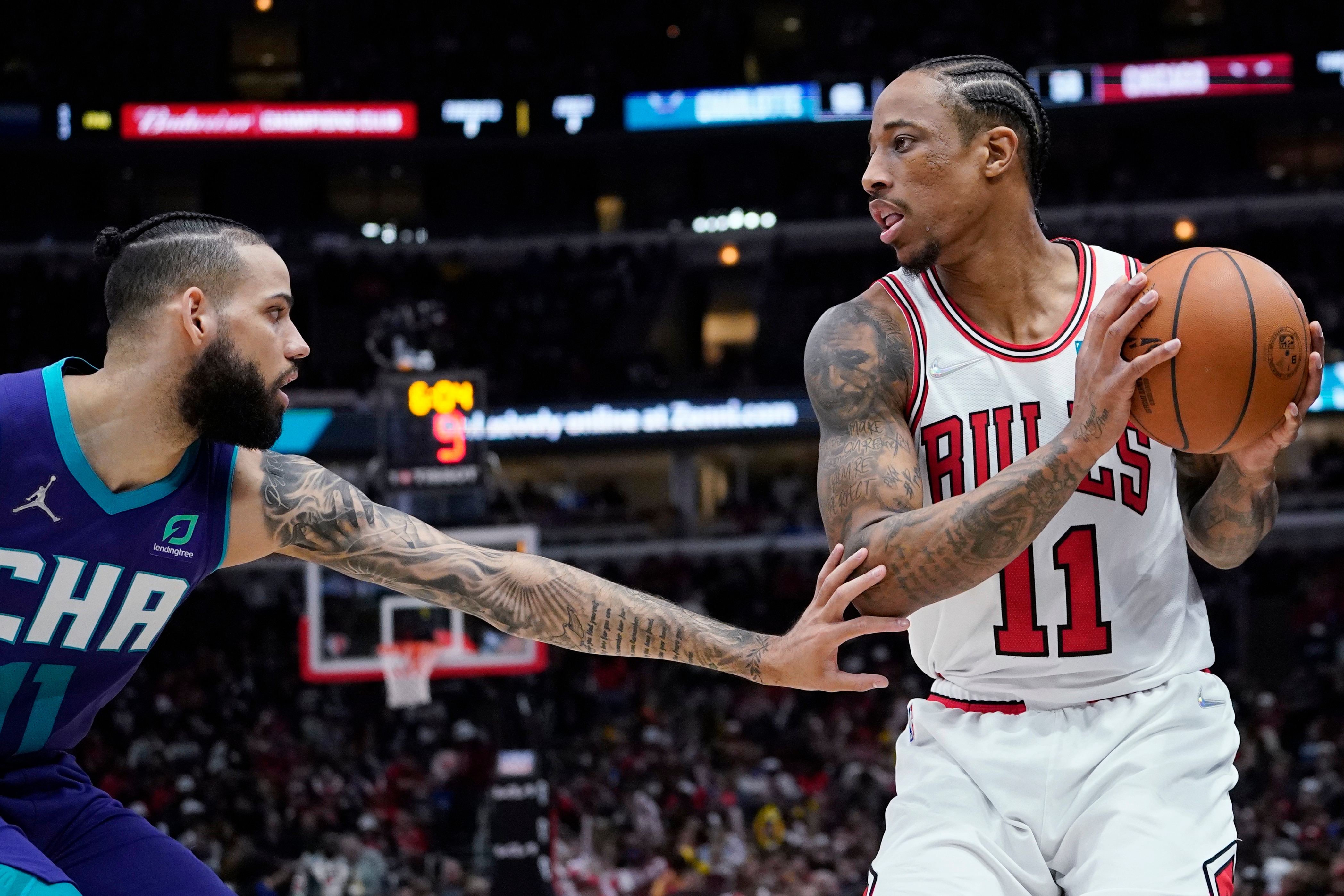 Chicago Bulls forward DeMar DeRozan, right, looks to pass as Charlotte Hornets forward Cody Martin guards during the second half of an NBA basketball game in Chicago, Friday, April 8, 2022. The Hornets won 133-117. (AP Photo/Nam Y. Huh)