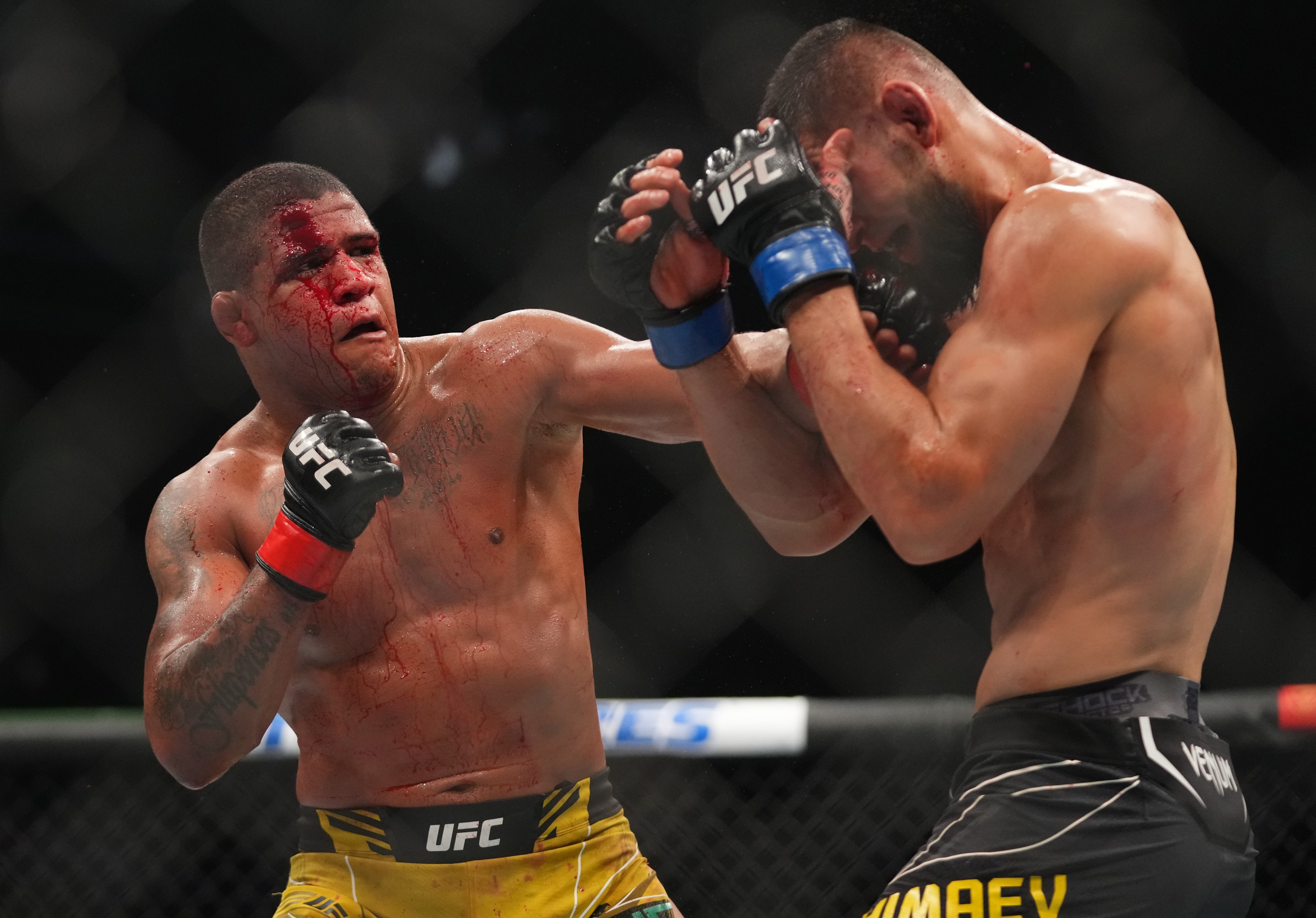 JACKSONVILLE, FLORIDA - APRIL 09: (L-R) Gilbert Burns of Brazil punches Khamzat Chimaev of Russia in their welterweight fight during the UFC 273 event at VyStar Veterans Memorial Arena on April 09, 2022 in Jacksonville, Florida. (Photo by Cooper Neill/Zuffa LLC)