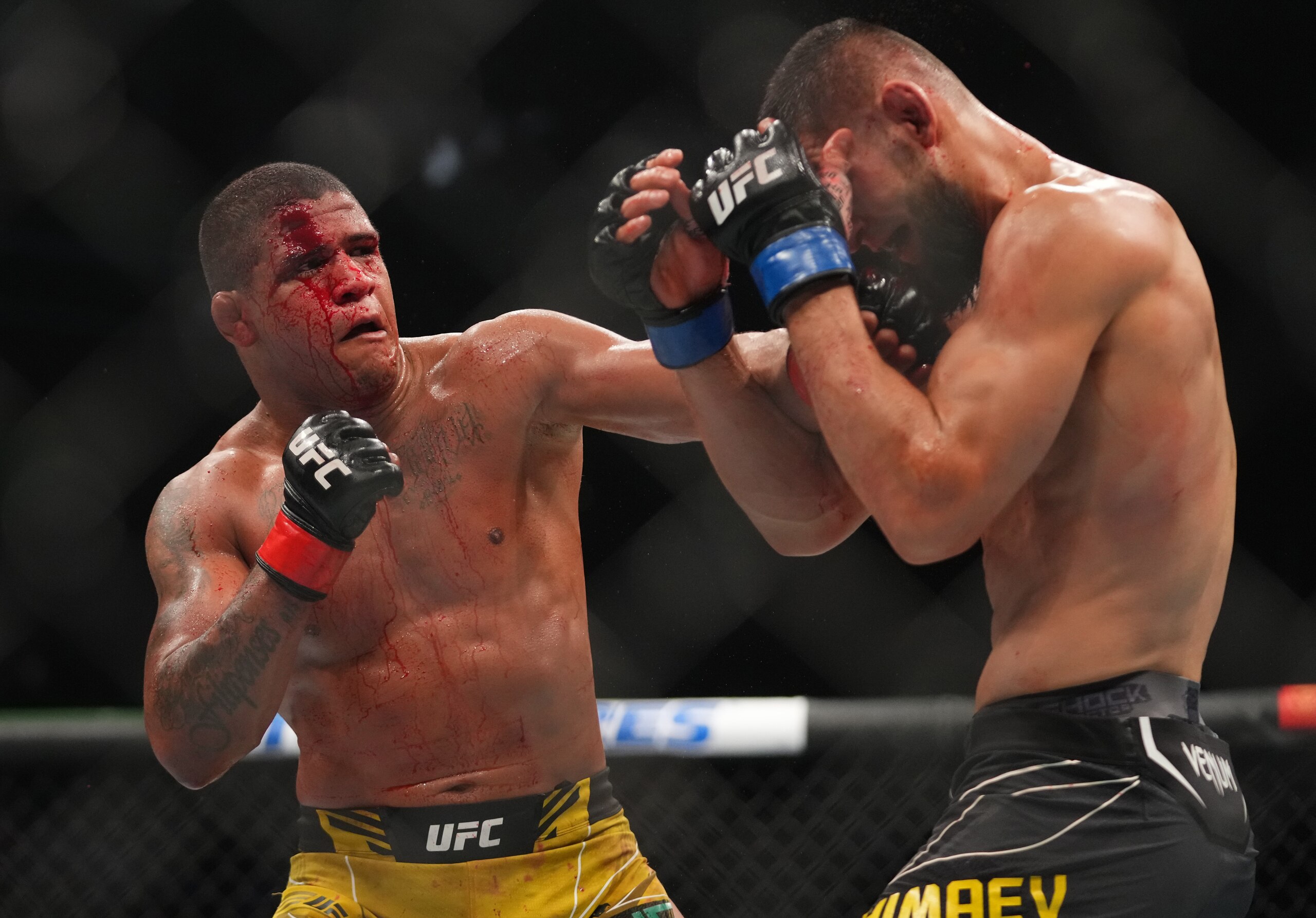 JACKSONVILLE, FLORIDA - APRIL 09: (L-R) Gilbert Burns of Brazil punches Khamzat Chimaev of Russia in their welterweight fight during the UFC 273 event at VyStar Veterans Memorial Arena on April 09, 2022 in Jacksonville, Florida. (Photo by Cooper Neill/Zuffa LLC)