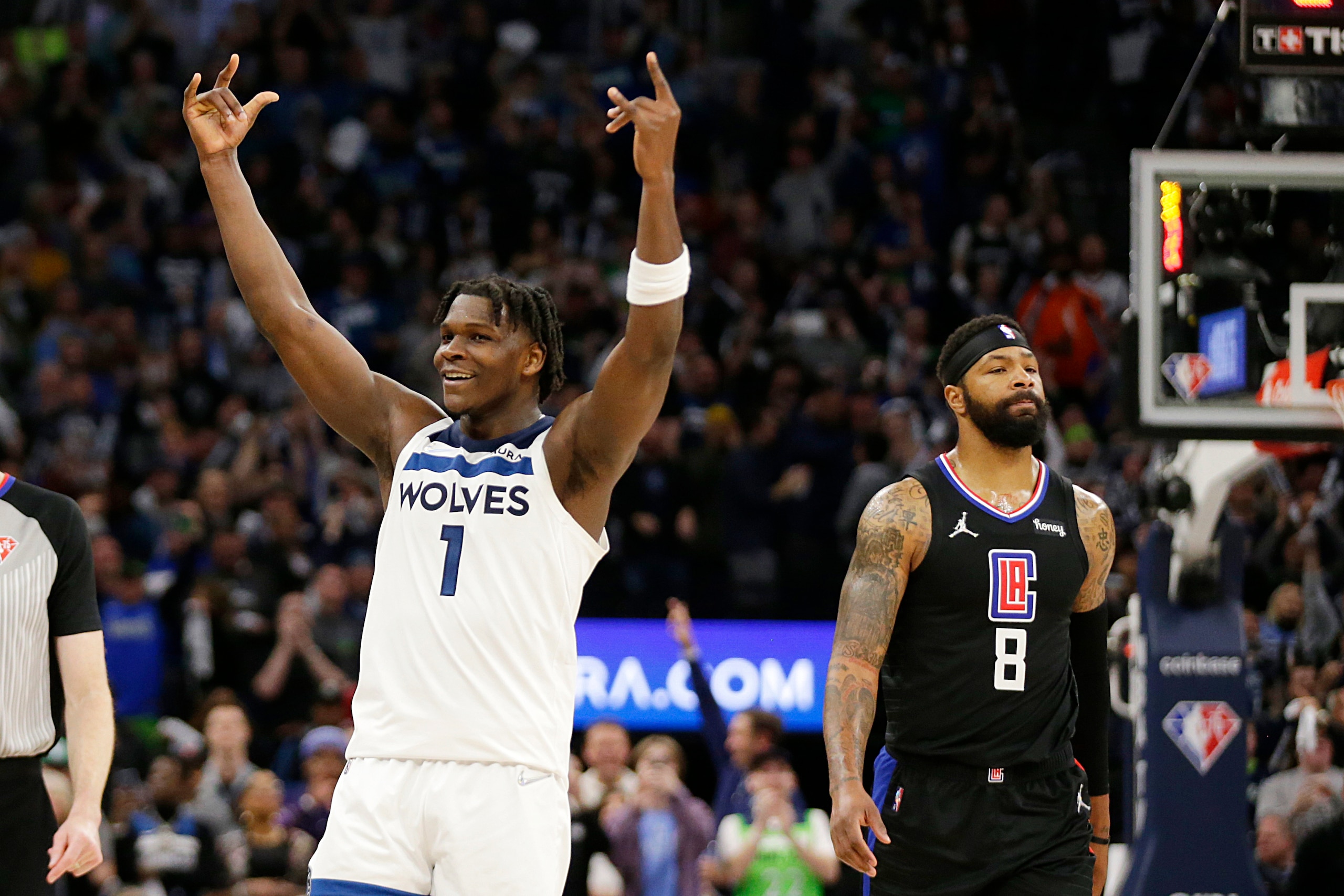 Minnesota Timberwolves forward Anthony Edwards (1) celebrates as Los Angeles Clippers forward Marcus Morris Sr. (8) walks past during the fourth quarter of an NBA basketball game Tuesday, April 12, 2022, in Minneapolis. (AP Photo/Andy Clayton-King)