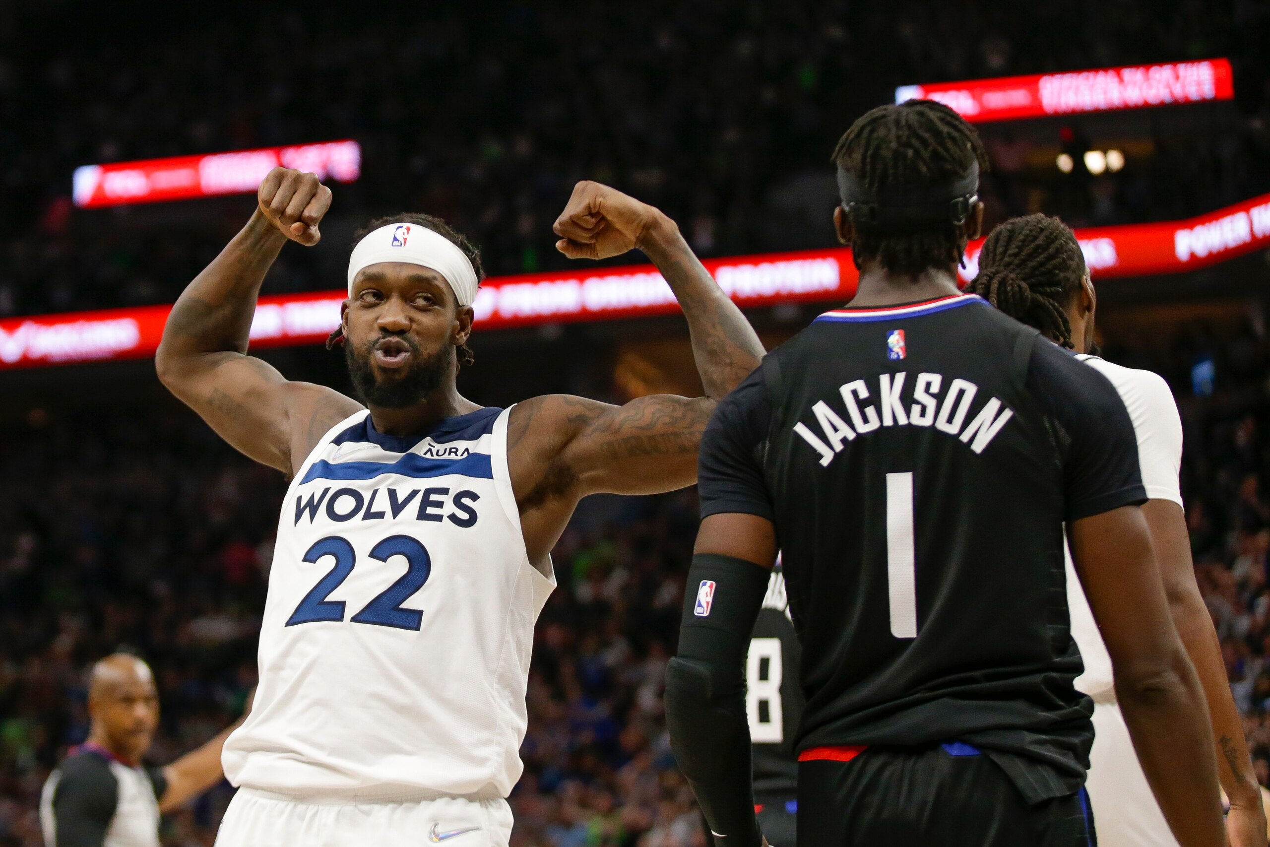 Minnesota Timberwolves guard Patrick Beverley (22) flexes in front of Los Angeles Clippers guard Reggie Jackson (1) during an NBA basketball game Tuesday, April 12, 2022, in Minneapolis. (AP Photo/Andy Clayton-King)