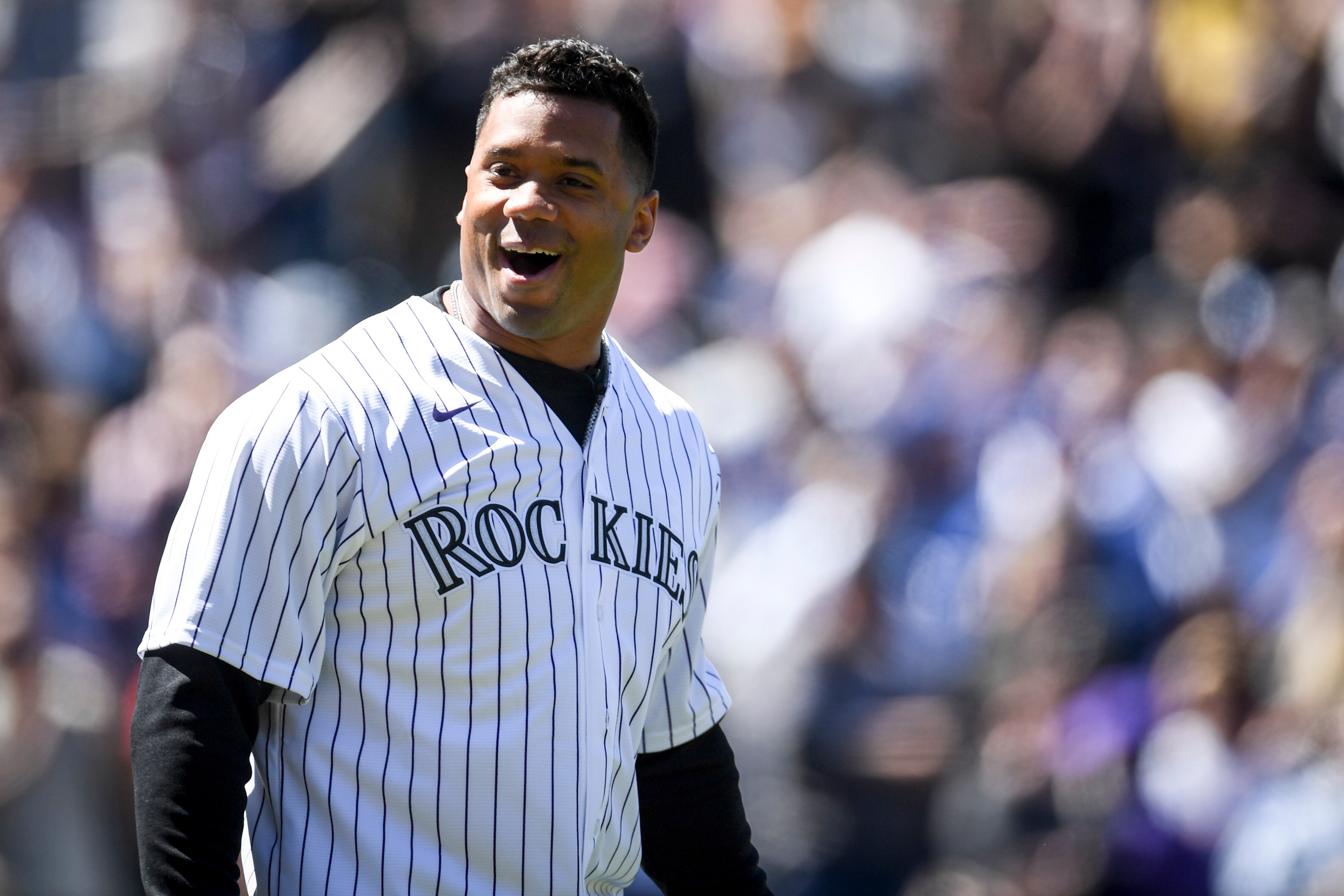 DENVER, CO - APRIL 8: Denver Broncos quarterback Russell Wilson shouts to the crowd ahead of throwing the first pitch before the first inning of Opening Day between the Colorado Rockies and the Los Angeles Dodgers at Coors Field on Friday, April 8, 2022. (Photo by AAron Ontiveroz/MediaNews Group/The Denver Post via Getty Images)