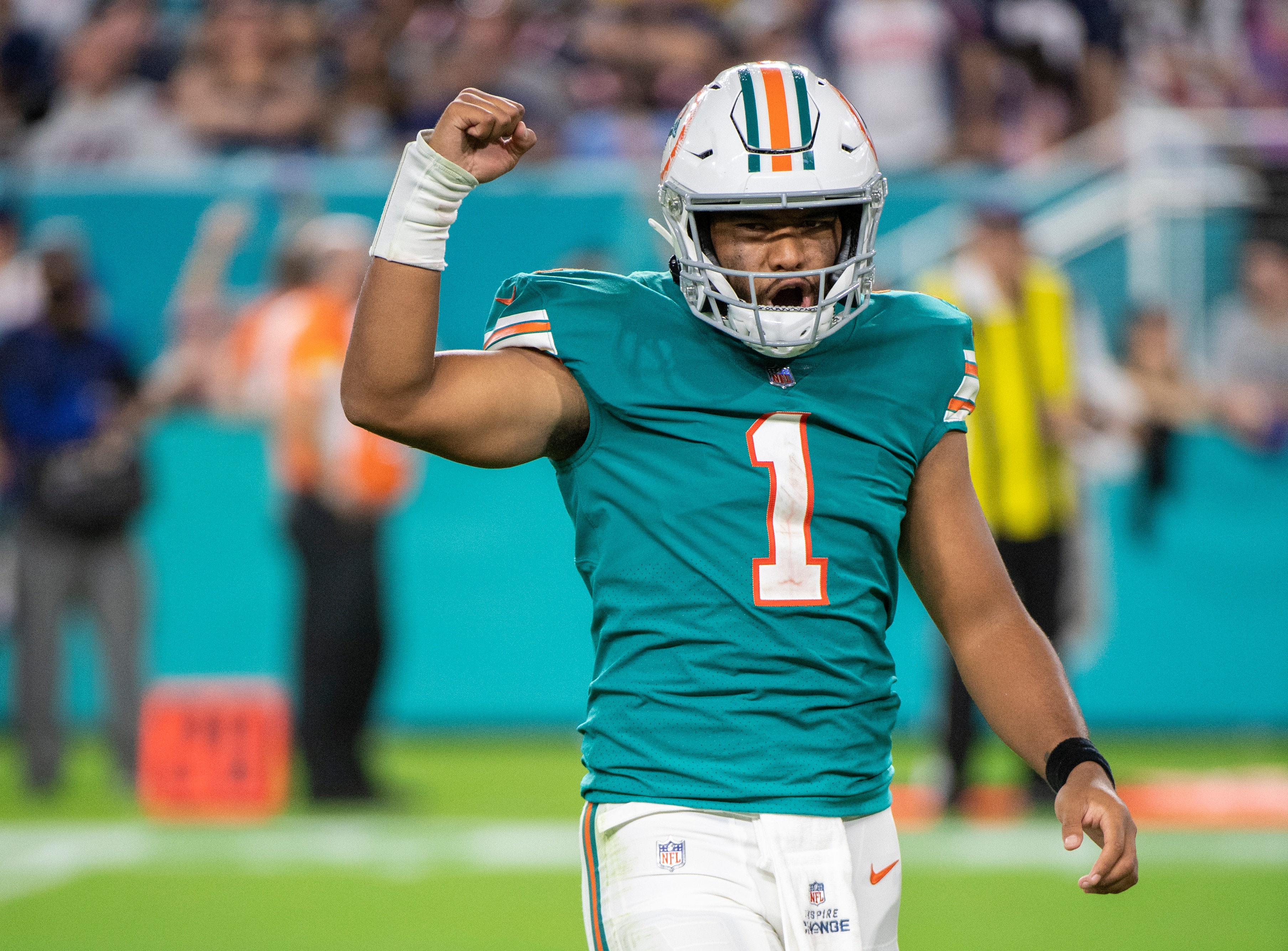 Miami Dolphins quarterback Tua Tagovailoa (1) raises his arm in the air as he celebrates Miami Dolphins running back Duke Johnson (not shown) scoring a touchdown during an NFL football game against the New England Patriots, Sunday, Jan. 9, 2022, in Miami Gardens, Fla. (AP Photo/Doug Murray)