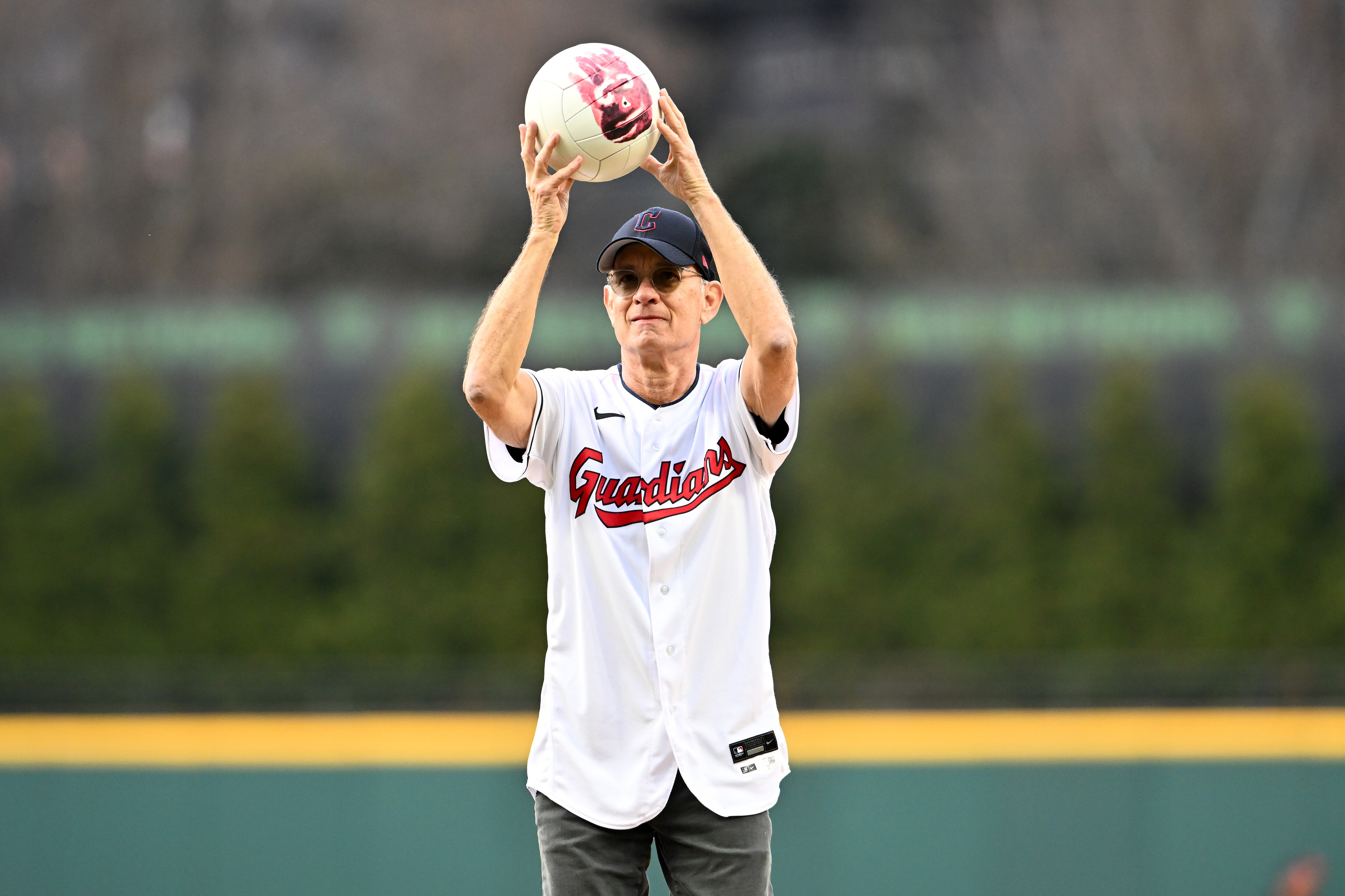 CLEVELAND, OHIO - APRIL 15: Actor and Cleveland Guardians fan Tom Hanks holds his co-star Wilson before throwing out the ceremonial first pitch prior to the home opener against the San Francisco Giants at Progressive Field on April 15, 2022 in Cleveland, Ohio. All players are wearing the number 42 in honor of Jackie Robinson Day. (Photo by Jason Miller/Getty Images)