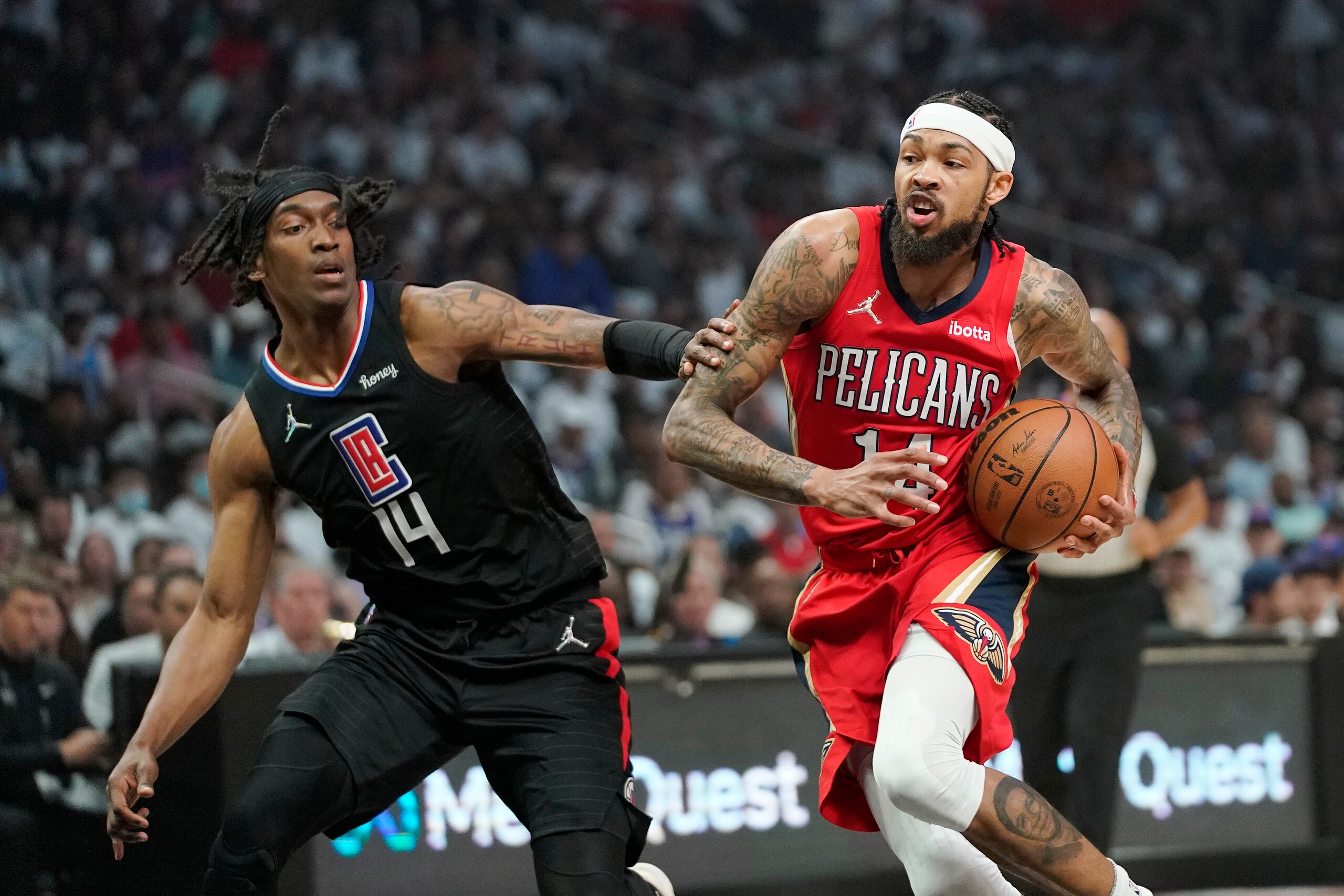 New Orleans Pelicans forward Brandon Ingram, right, drives past Los Angeles Clippers guard Terance Mann during the first half of an NBA basketball play-in tournament game Friday, April 15, 2022, in Los Angeles. (AP Photo/Mark J. Terrill)