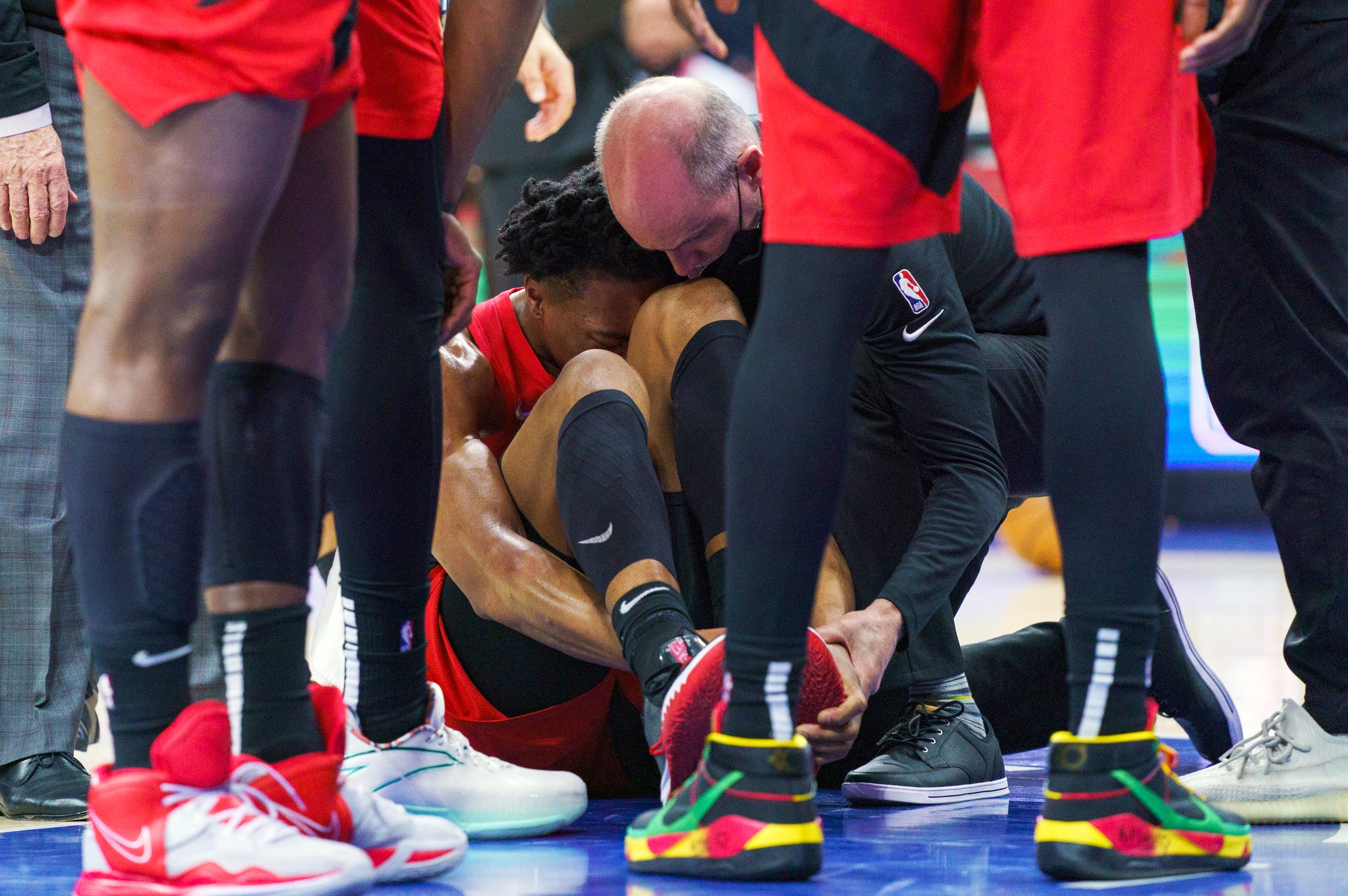 Toronto Raptors' Scottie Barnes, center, gets looked over by the training staff after injuring his left leg during the second half of Game 1 of an NBA basketball first-round playoff series against the Philadelphia 76ers, Saturday, April 16, 2022, in Philadelphia. The 76ers won 131-111. (AP Photo/Chris Szagola) Toronto Raptors' Scottie Barnes, center, gets looked over by the training staff after injuring his left leg during the second half of Game 1 of an NBA basketball first-round playoff series against the Philadelphia 76ers, Saturday, April 16, 2022, in Philadelphia. The 76ers won 131-111. (AP Photo/Chris Szagola)