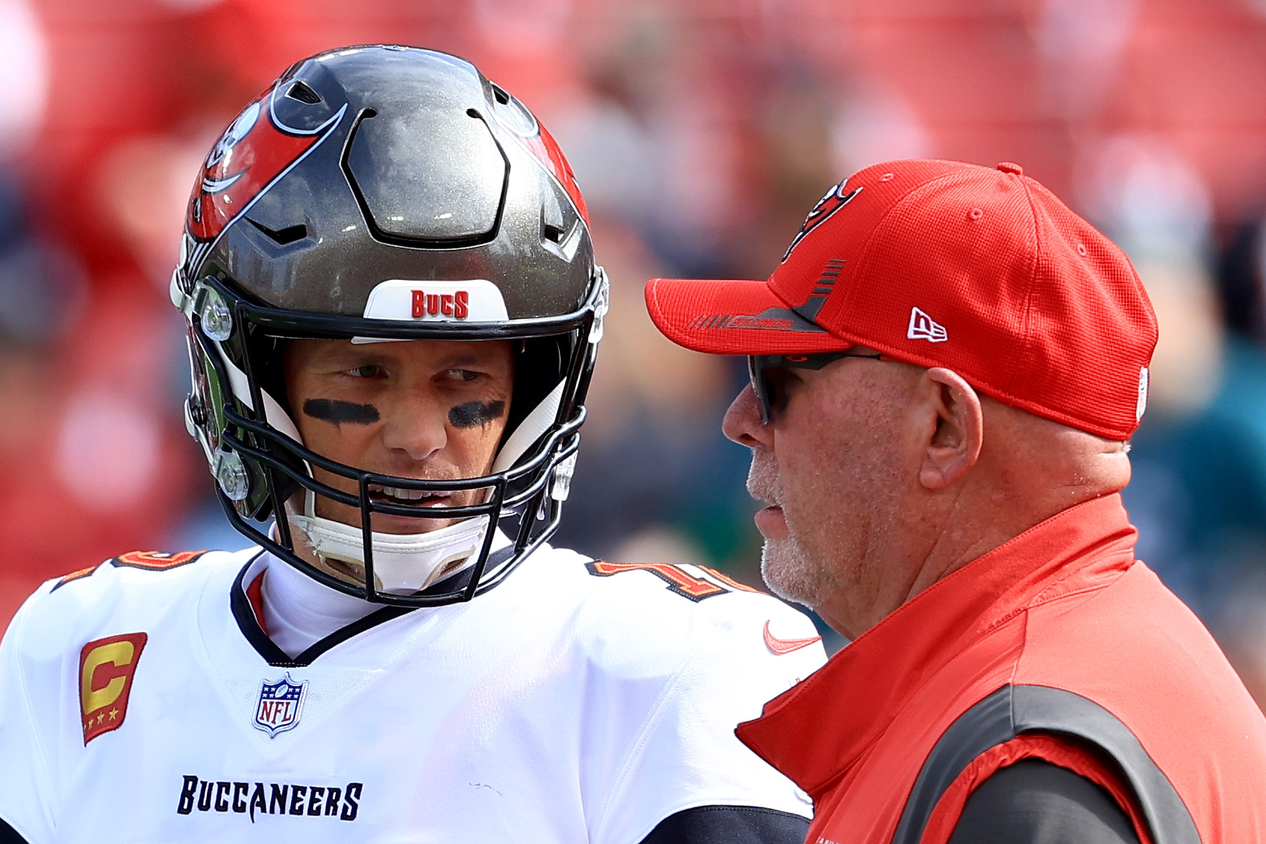 TAMPA, FLORIDA - JANUARY 16: Tom Brady #12 of the Tampa Bay Buccaneers talks with head coach Bruce Arians prior to the NFC Wild Card Playoff game against the Philadelphia Eagles at Raymond James Stadium on January 16, 2022 in Tampa, Florida. (Photo by Mike Ehrmann/Getty Images)