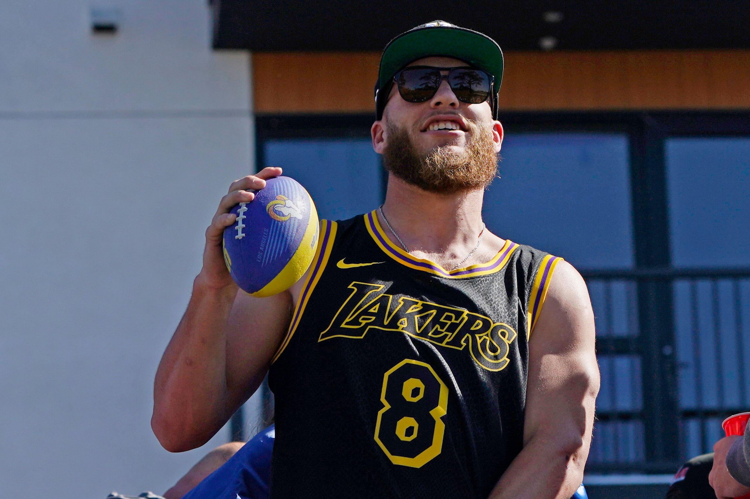 Los Angeles Rams wide receiver Cooper Kupp holds a football as he rides on a bus during the team's victory parade in Los Angeles, Wednesday, Feb. 16, 2022, following their win Sunday over the Cincinnati Bengals in the NFL Super Bowl 56 football game. (AP Photo/Marcio Jose Sanchez)