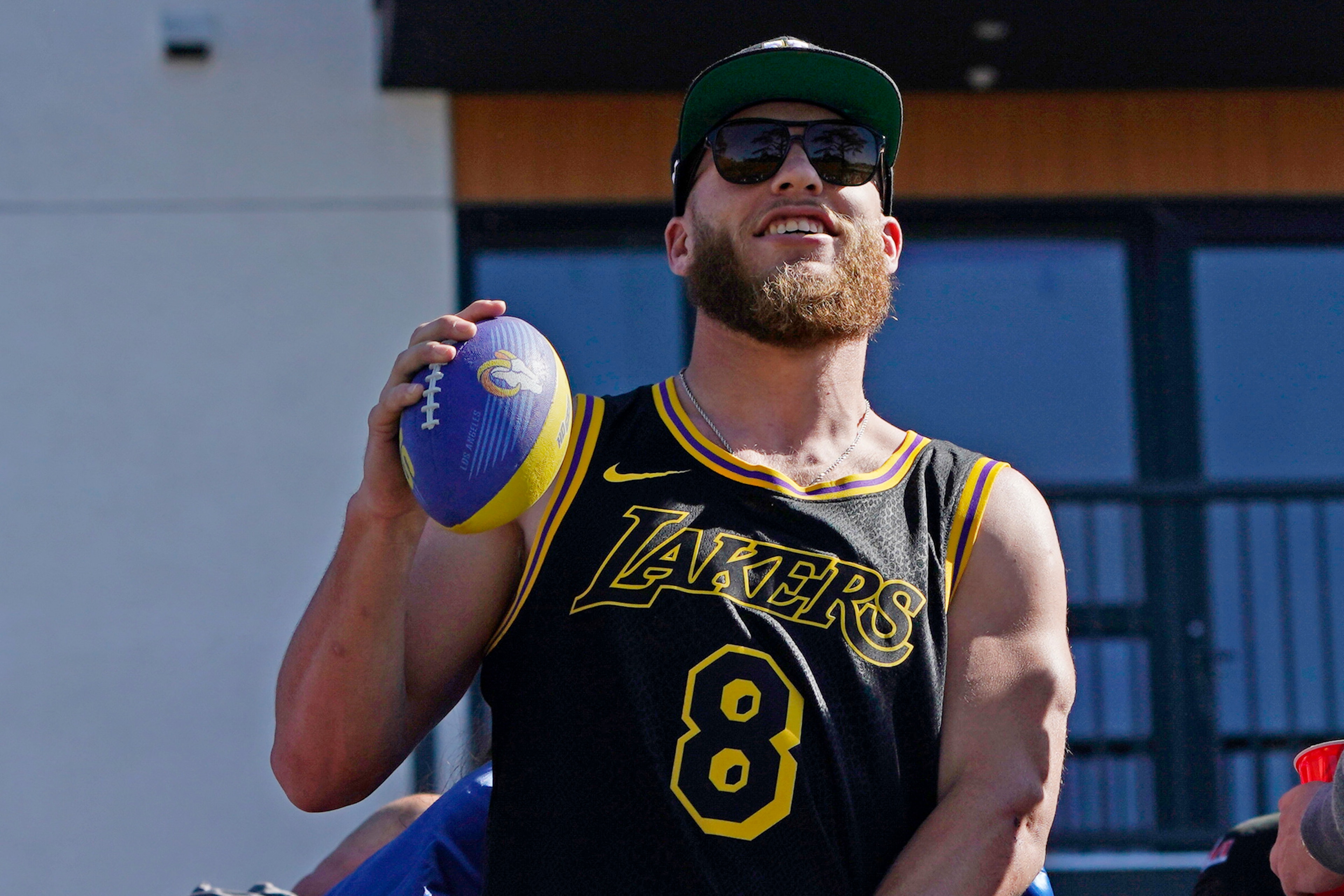 Los Angeles Rams wide receiver Cooper Kupp holds a football as he rides on a bus during the team's victory parade in Los Angeles, Wednesday, Feb. 16, 2022, following their win Sunday over the Cincinnati Bengals in the NFL Super Bowl 56 football game. (AP Photo/Marcio Jose Sanchez)
