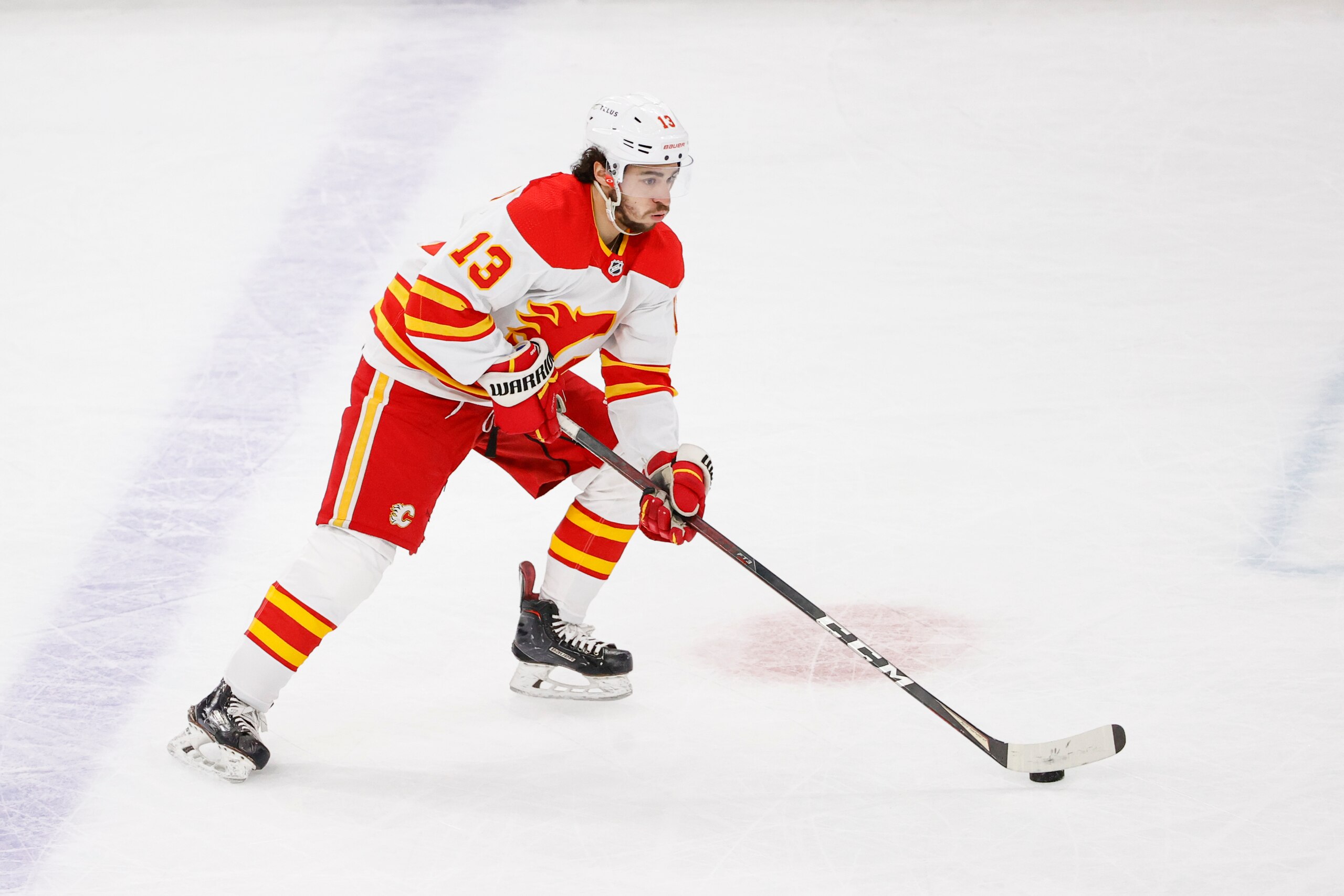 Calgary Flames left wing Johnny Gaudreau (13) looks to pass the puck against the Chicago Blackhawks during the first period of an NHL hockey game, Monday, April 18, 2022, in Chicago. (AP Photo/Kamil Krzaczynski)