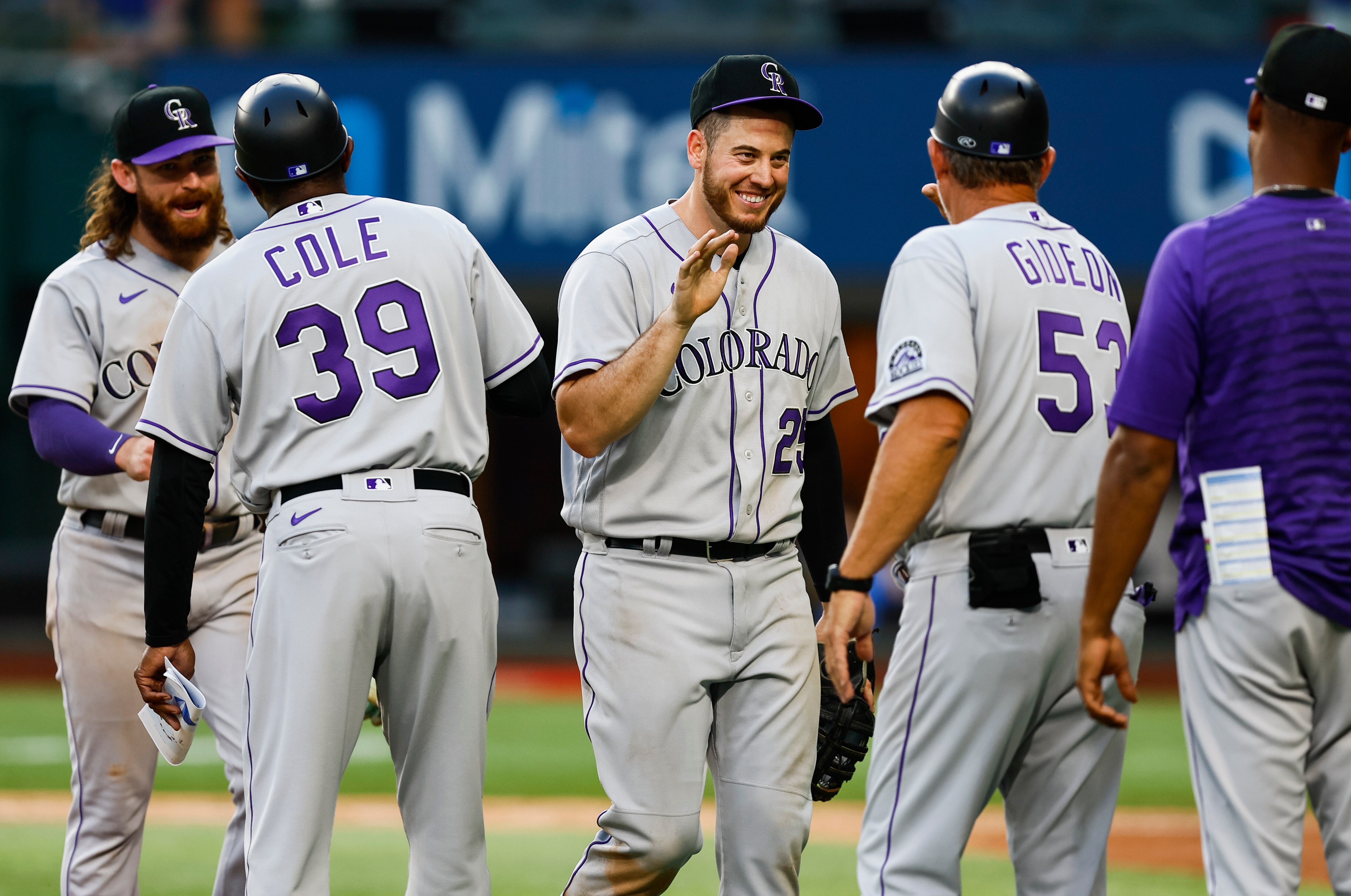ARLINGTON, TX - APRIL 11: C.J. Cron #25 of the Colorado Rockies is congratulated by first base coach Ronnie Gideon #53 after a 6-4, 10th-inning win over the Texas Rangers in the home opener at Globe Life Field April 11, 2022 in Arlington, Texas. Colorado won 6-4 in ten innings. (Photo by Brandon Wade/Getty Images)