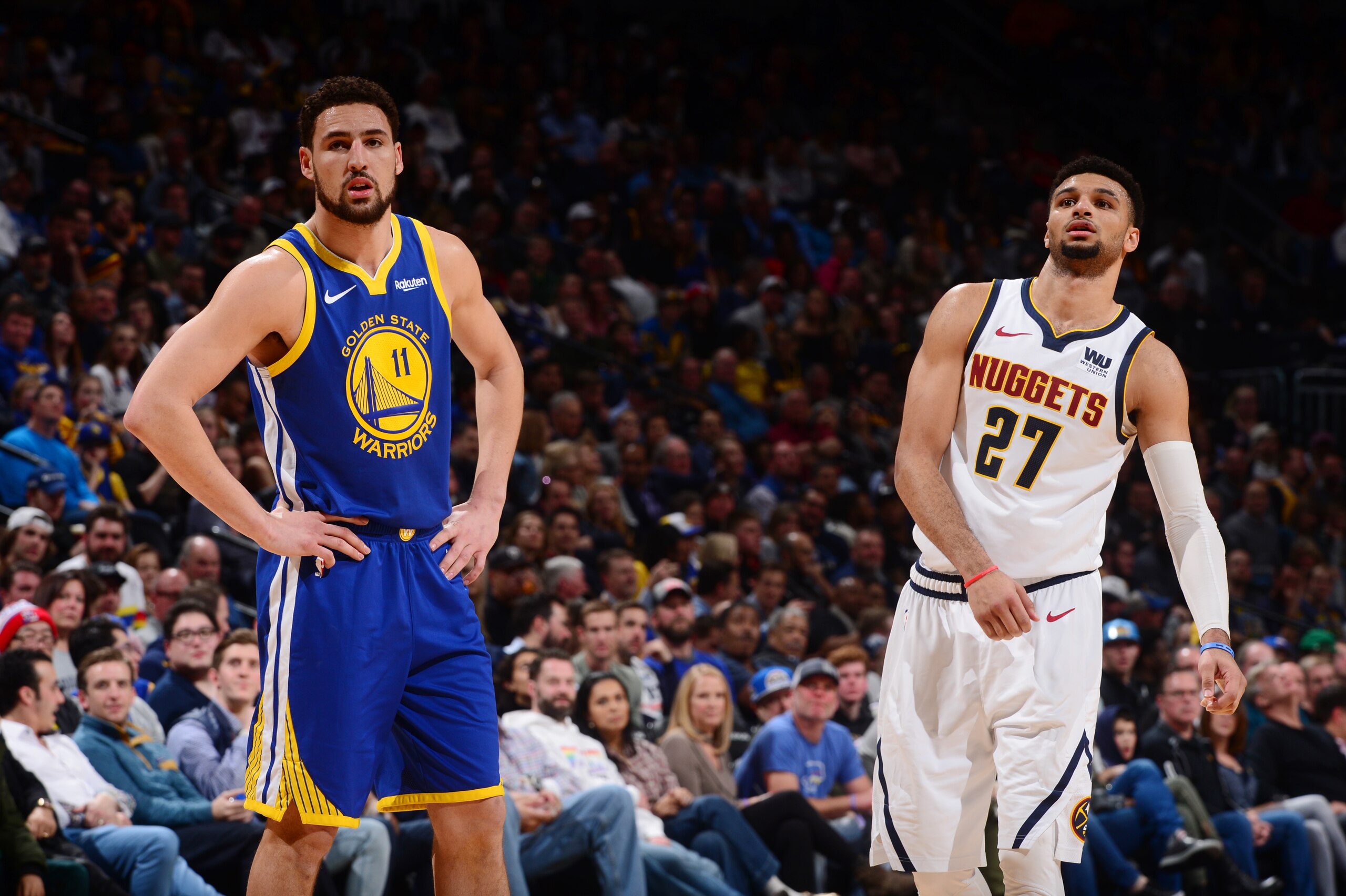 DENVER, CO - JANUARY 15:  Klay Thompson #11 of the Golden State Warriors and Jamal Murray #27 of the Denver Nuggets look on during the game on January 15, 2019 at the Pepsi Center in Denver, Colorado. NOTE TO USER: User expressly acknowledges and agrees that, by downloading and/or using this Photograph, user is consenting to the terms and conditions of the Getty Images License Agreement. Mandatory Copyright Notice: Copyright 2019 NBAE (Photo by Bart Young/NBAE via Getty Images)