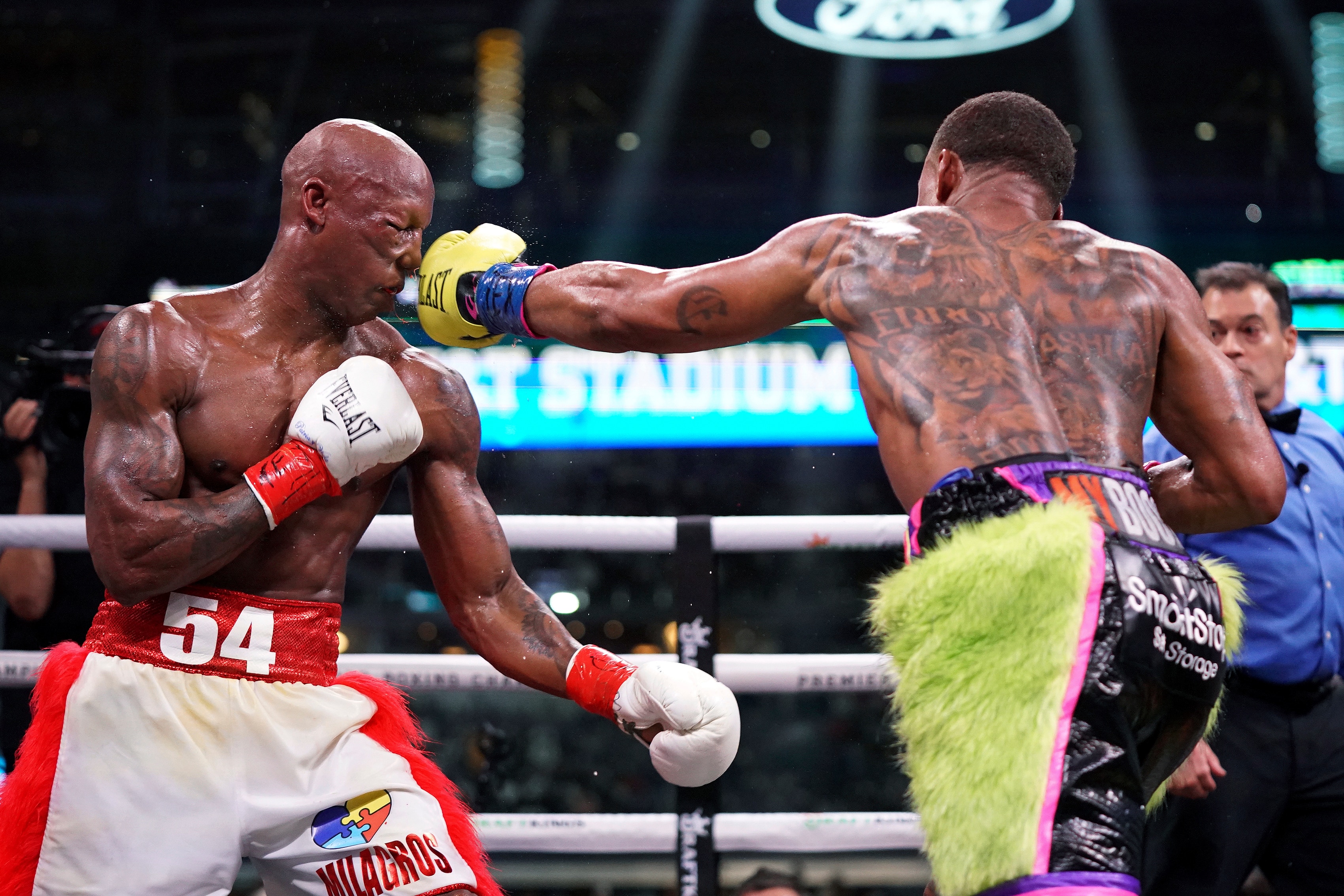 Errol Spence Jr., right, lands a punch on Yordenis Ugas, from Cuba, during a world welterweight championship boxing match Saturday, April 16, 2022, in Arlington, Texas. (AP Photo/Jeffrey McWhorter)