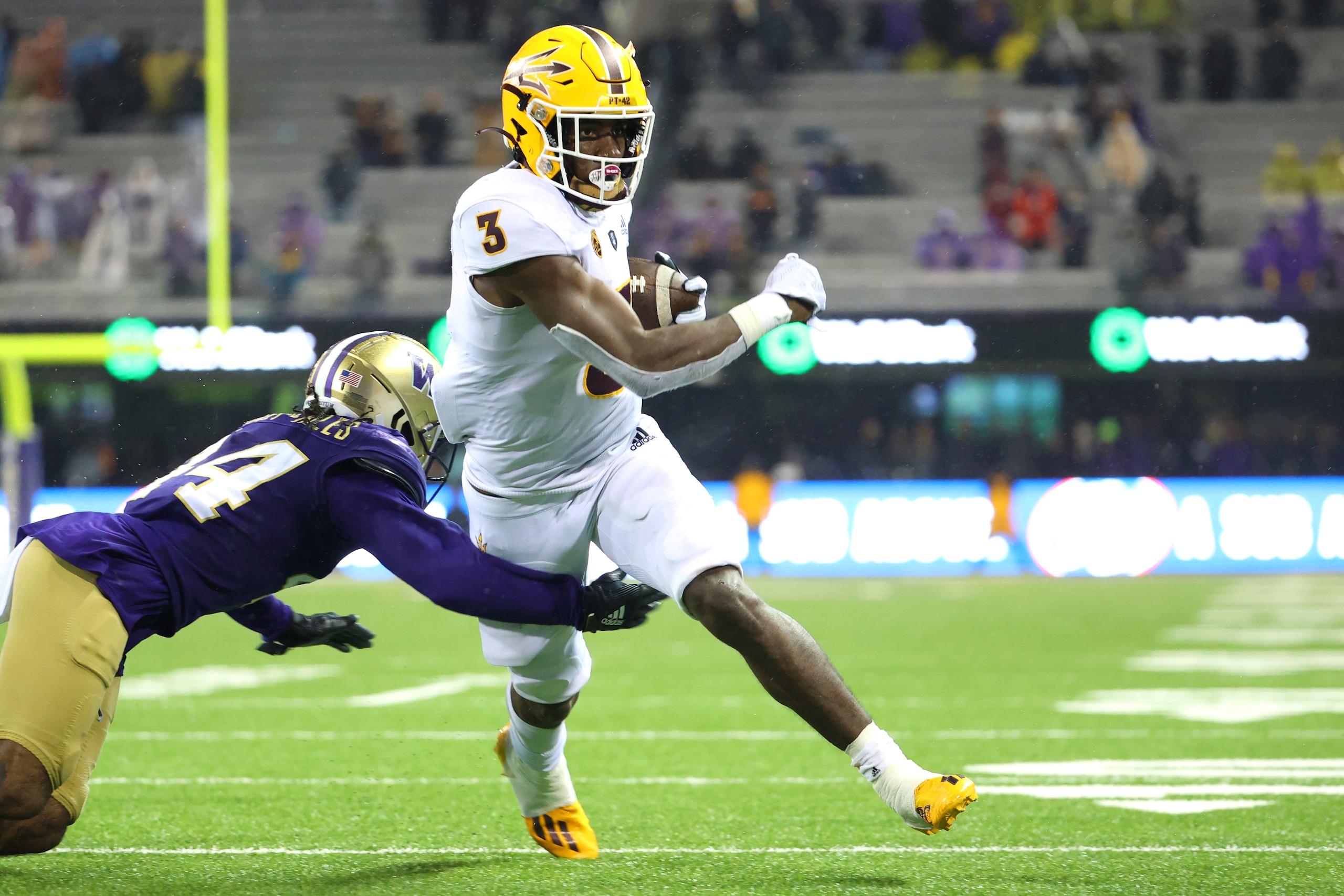 SEATTLE, WASHINGTON - NOVEMBER 13: Rachaad White #3 of the Arizona State Sun Devils breaks a tackle against Brendan Radley-Hiles #44 of the Washington Huskies to score the game-winning touchdown in the fourth quarter at Husky Stadium on November 13, 2021 in Seattle, Washington. (Photo by Abbie Parr/Getty Images)