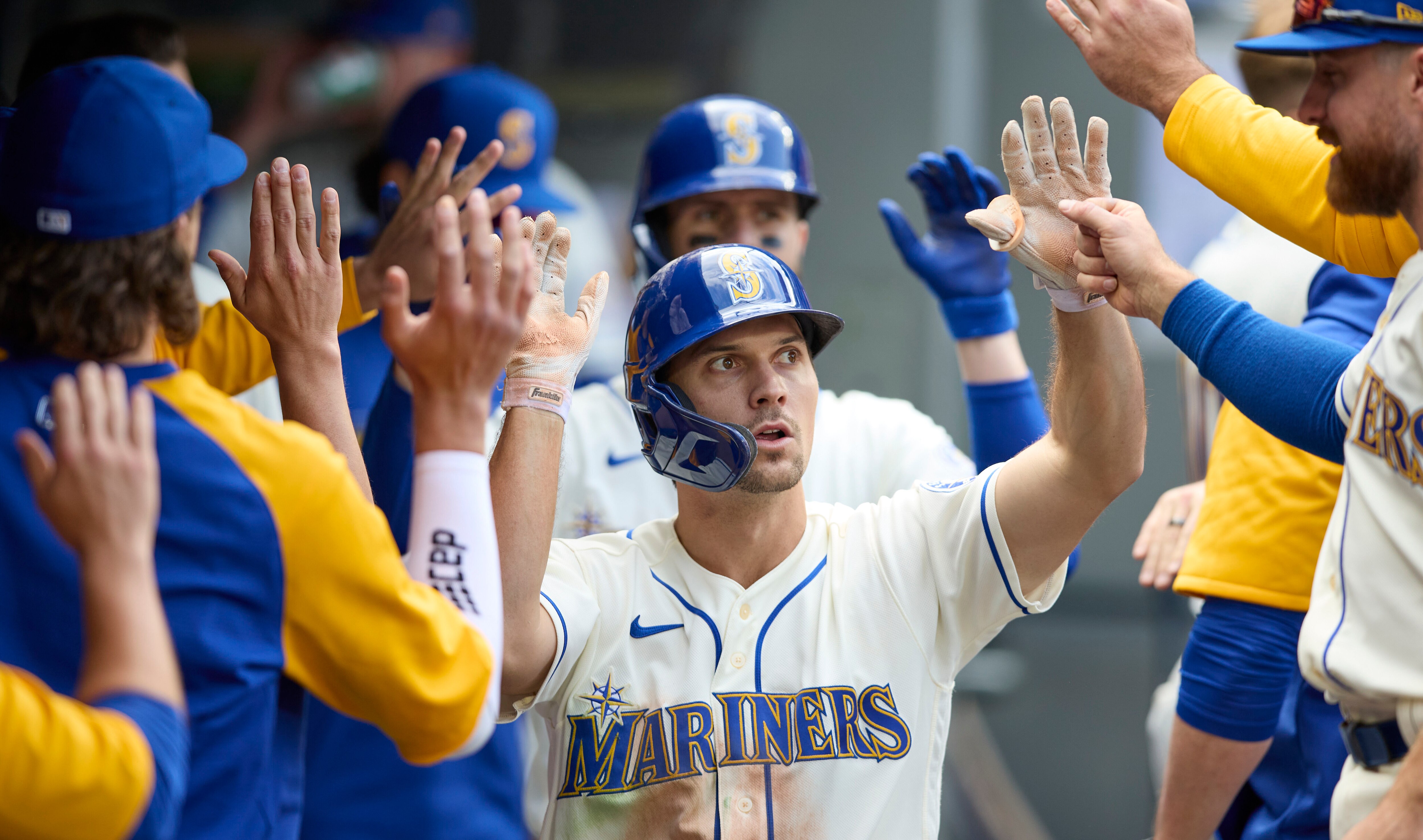 Seattle Mariners' Adam Frazier is congratulated after scoring against the Kansas City Royals during the 10th inning of a baseball game, Sunday, April 24, 2022, in Seattle. (AP Photo/John Froschauer)