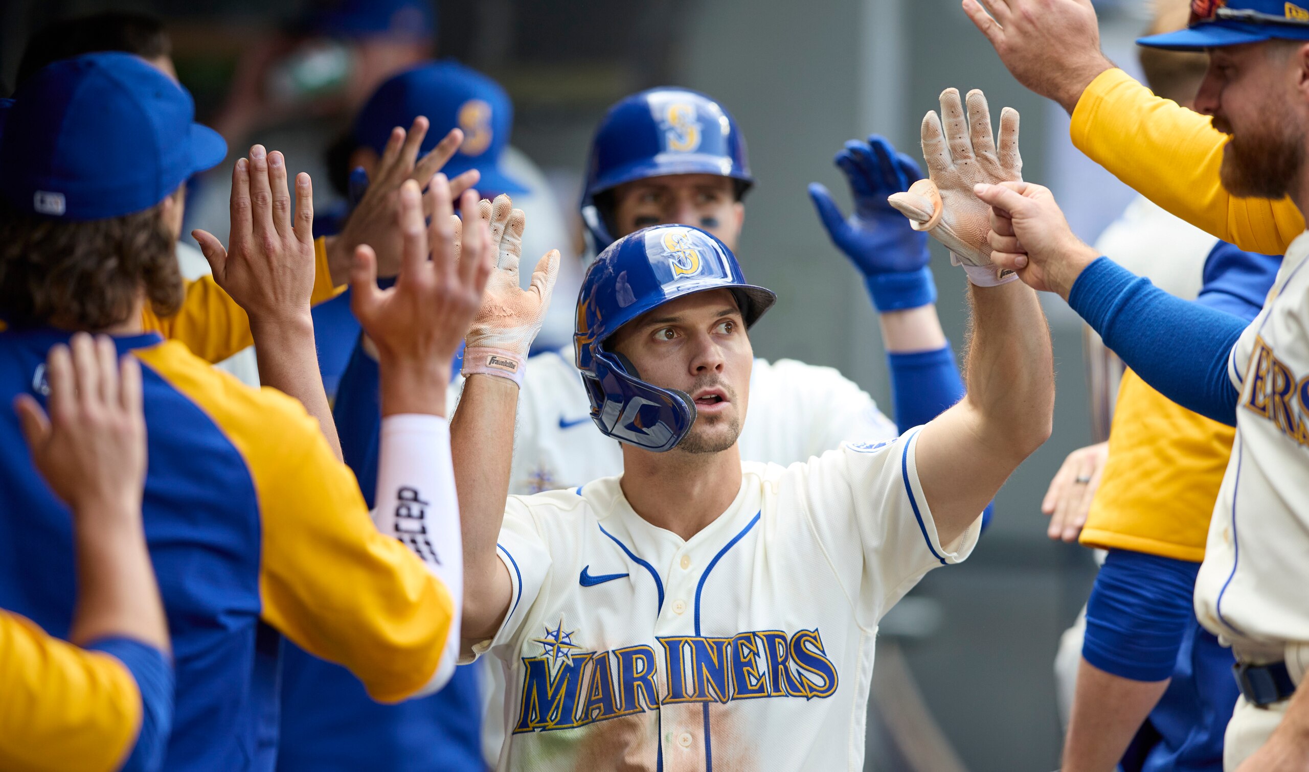 Seattle Mariners' Adam Frazier is congratulated after scoring against the Kansas City Royals during the 10th inning of a baseball game, Sunday, April 24, 2022, in Seattle. (AP Photo/John Froschauer)