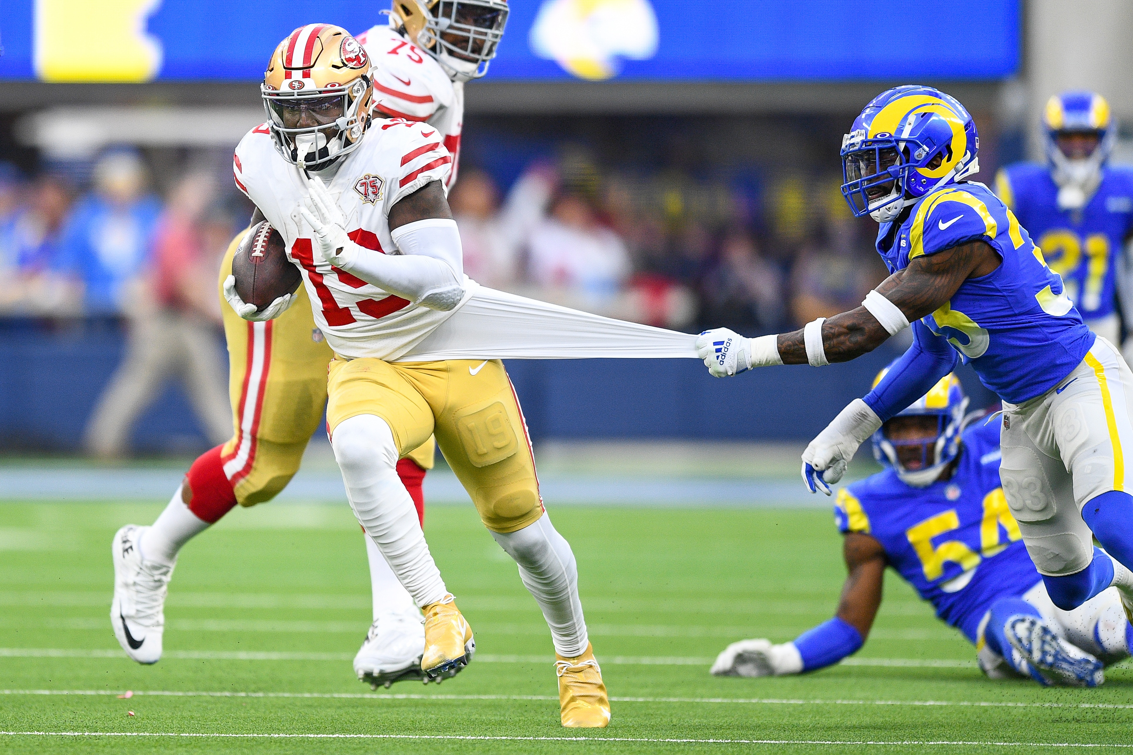 INGLEWOOD, CA - JANUARY 09: San Francisco 49ers Wide Receiver Deebo Samuel (19) runs after a catch as Los Angeles Rams Safety Nick Scott (33) pulls on his jersey during the NFL game between the San Francisco 49ers and the Los Angeles Rams on January 9, 2022, at SoFi Stadium in Inglewood, CA. (Photo by Brian Rothmuller/Icon Sportswire via Getty Images)