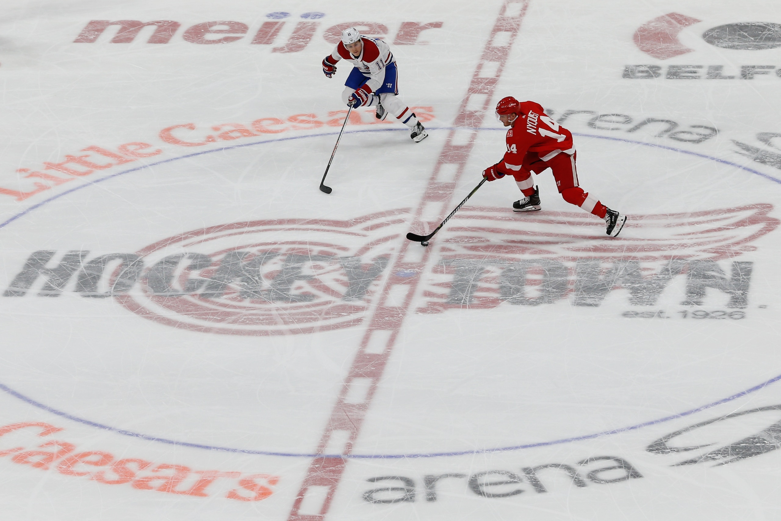 DETROIT, MI - APRIL 05:  Detroit Red Wings forward Gustav Nyquist, of Sweden, (14) skates with the puck against Montreal Canadiens forward Brendan Gallagher (11) across the Hockeytown logo at center ice during a regular season NHL hockey game between the Montreal Canadiens and the Detroit Red Wings on April 5, 2018, at Little Caesars Arena in Detroit, Michigan.  (Photo by Scott W. Grau/Icon Sportswire via Getty Images)