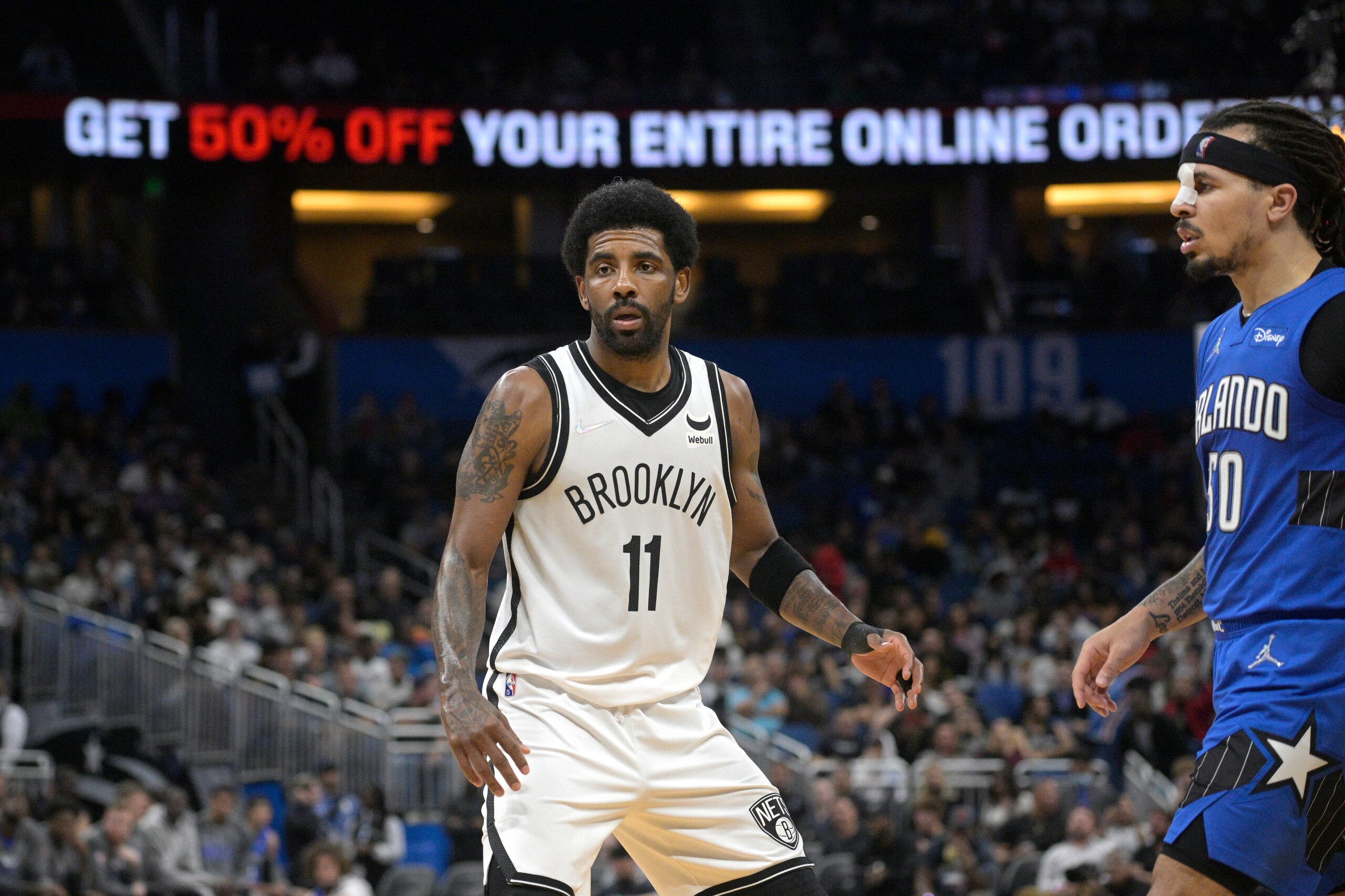Brooklyn Nets guard Kyrie Irving (11) defends against Orlando Magic guard Cole Anthony (50) during the second half of an NBA basketball game, Tuesday, March 15, 2022, in Orlando, Fla. (AP Photo/Phelan M. Ebenhack)