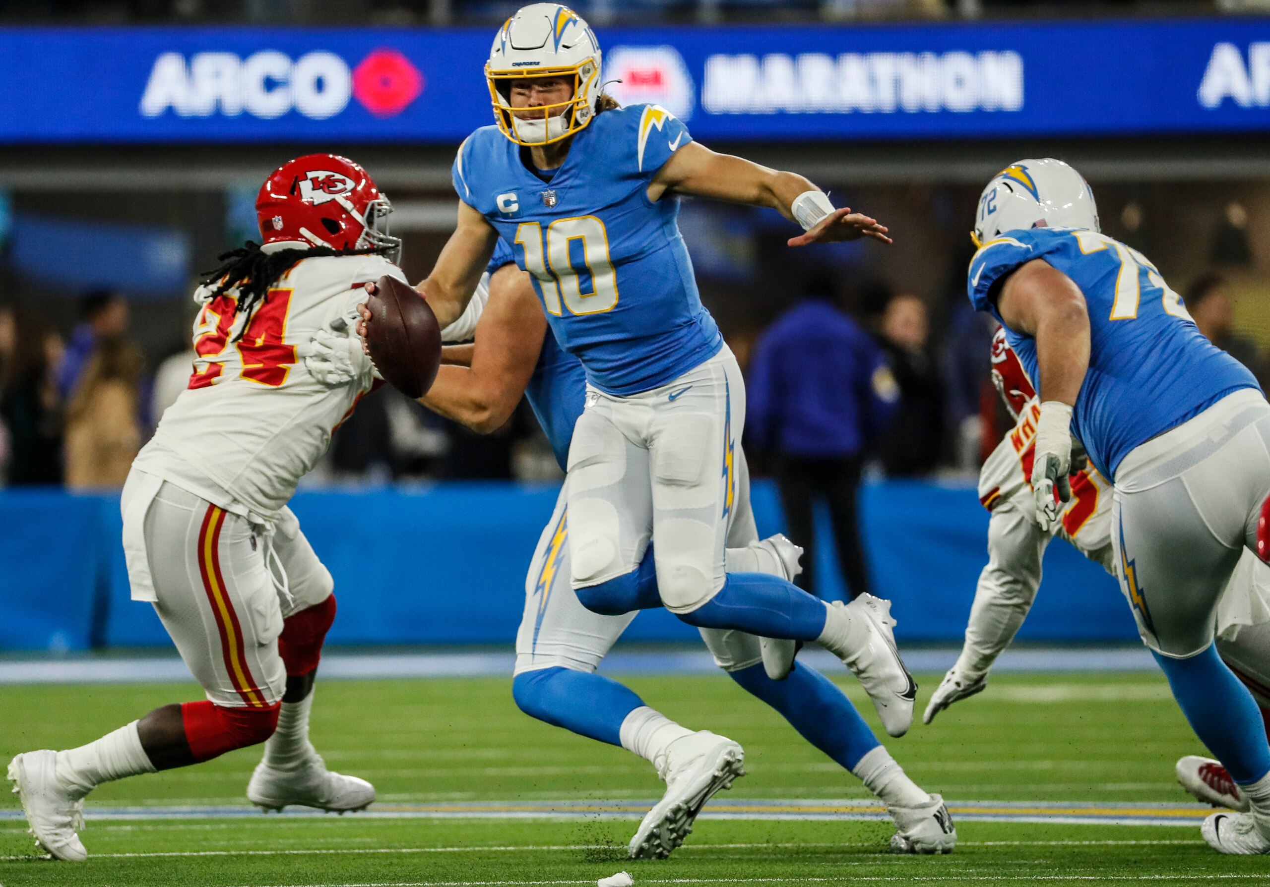 Inglewood, CA, Thursday, December 16, 2021  - Los Angeles Chargers quarterback Justin Herbert (10) hops out of the pocket to scramble past Chiefs linebacker Melvin Ingram on a second half drive at SoFi Stadium. (Robert Gauthier/Los Angeles Times via Getty Images)