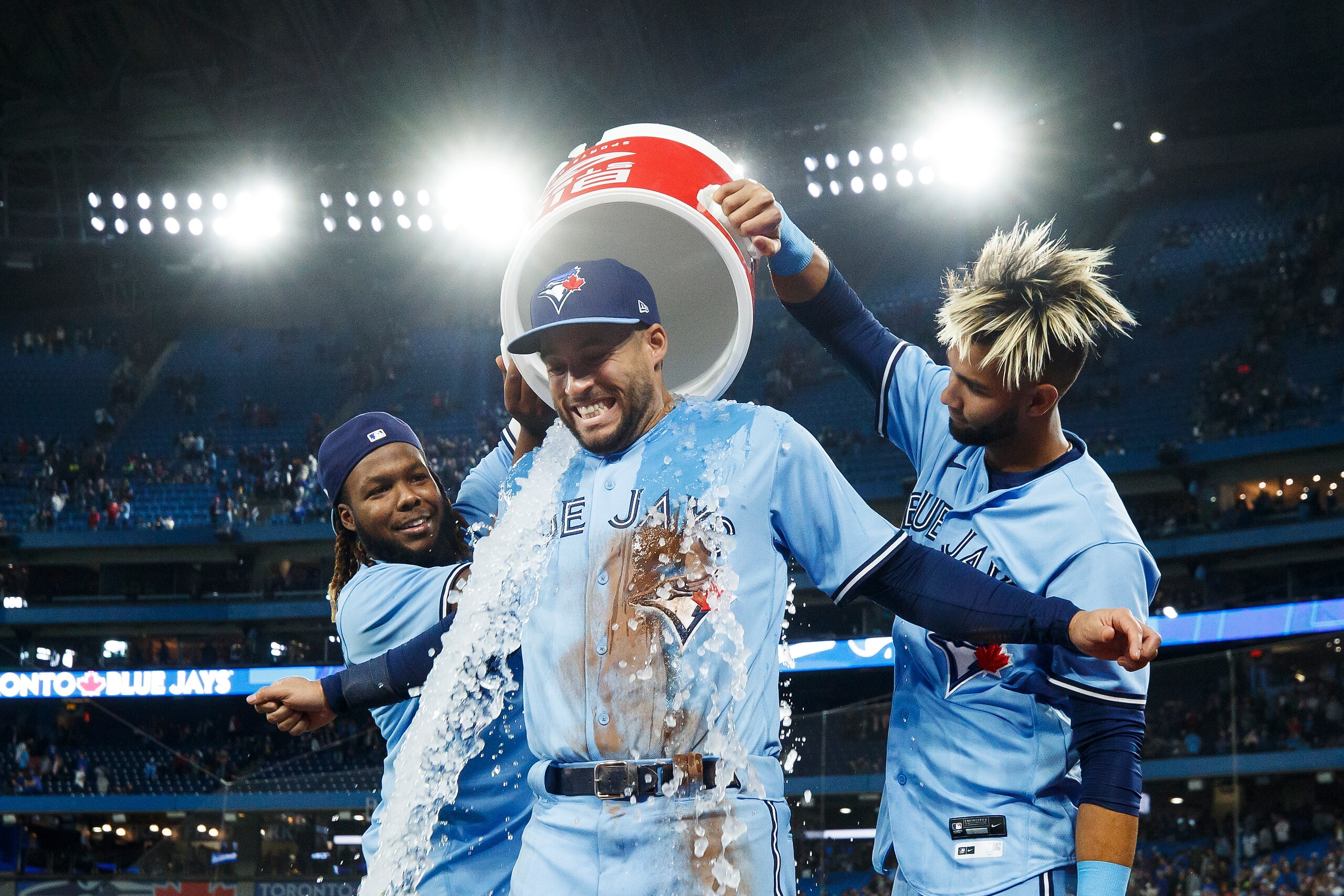 TORONTO, ON - APRIL 30: Vladimir Guerrero Jr. #27 and Lourdes Gurriel Jr. #13 of the Toronto Blue Jays pour ice on George Springer #4 after their 2-1 MLB game against the Houston Astros at Rogers Centre on April 30, 2022 in Toronto, Canada. (Photo by Cole Burston/Getty Images)