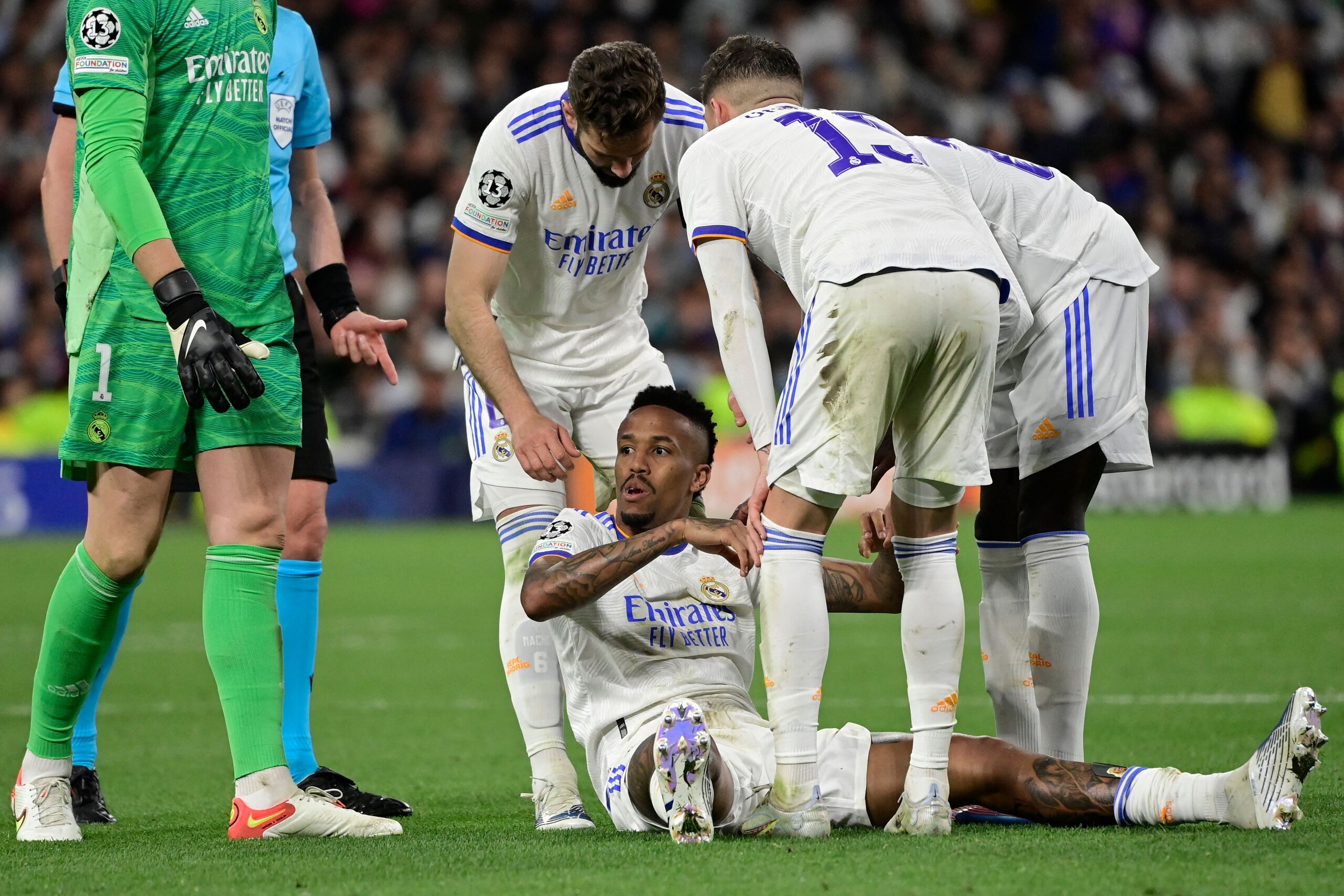 Real Madrid's Brazilian defender Eder Militao (C) receives assistance from teammates after a fall during the UEFA Champions League semi-final second leg football match between Real Madrid CF and Manchester City at the Santiago Bernabeu stadium in Madrid on May 4, 2022. (Photo by JAVIER SORIANO / AFP) (Photo by JAVIER SORIANO/AFP via Getty Images)