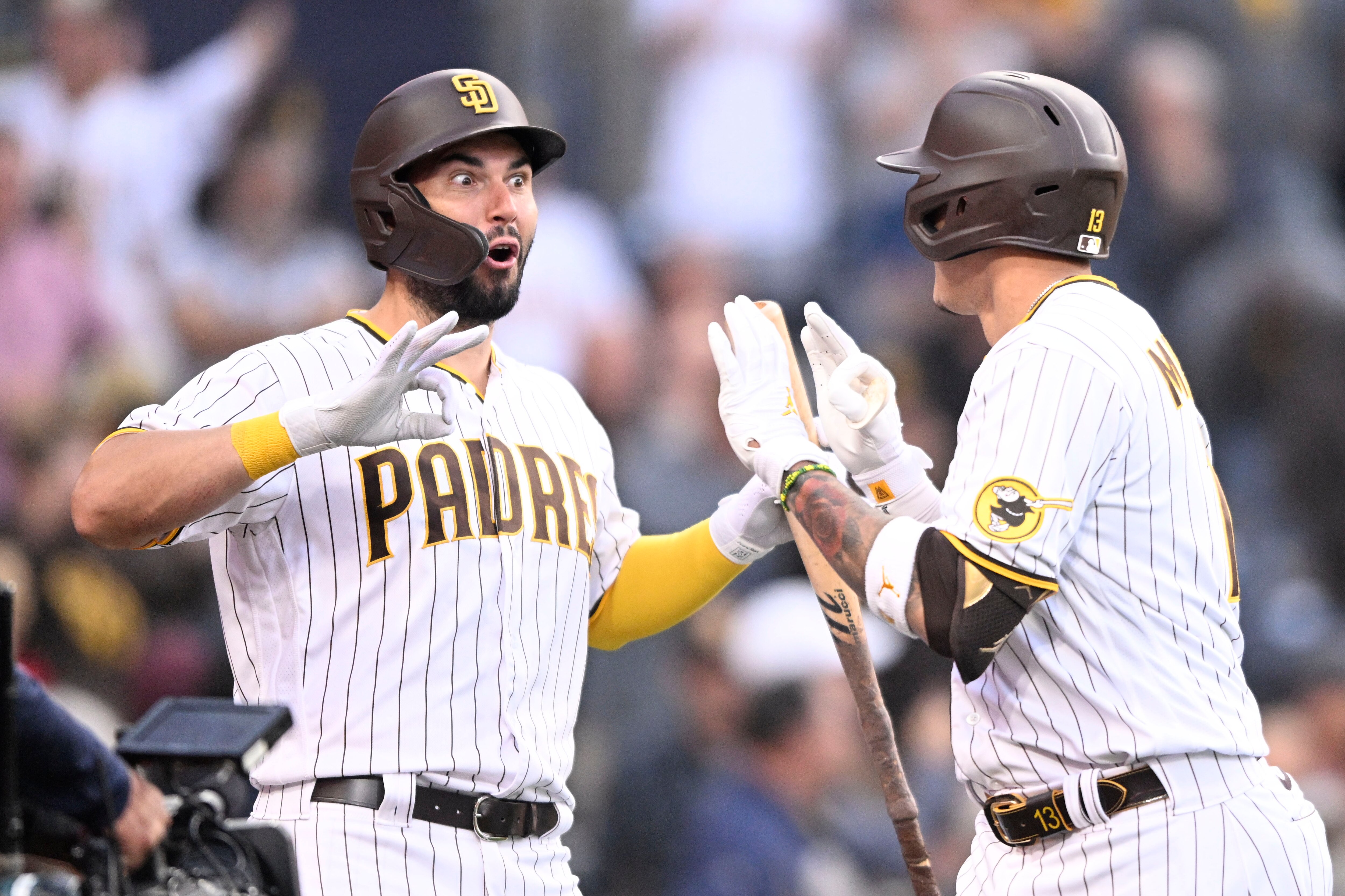 SAN DIEGO, CA - MAY 5 : Manny Machado #13 of the San Diego Padres, right, is congratulated by Eric Hosmer #30 after he hit a solo home run during the first inning of a baseball game against the Miami Marlins on May 5, 2022 at Petco Park in San Diego, California. (Photo by Denis Poroy/Getty Images)
