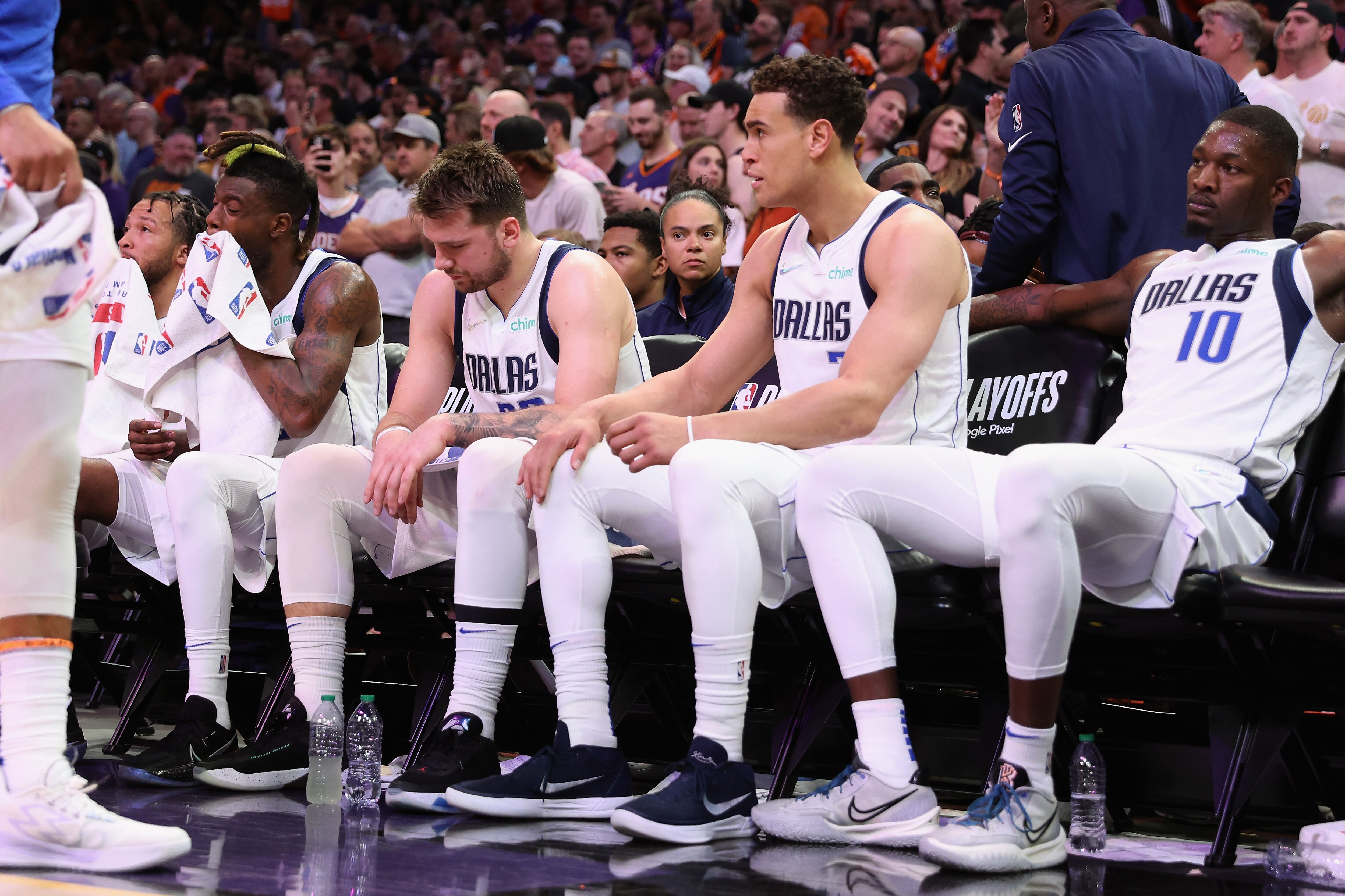 PHOENIX, ARIZONA - MAY 04: (L-R) Reggie Bullock #25, Luka Doncic #77, Dwight Powell #7 and Dorian Finney-Smith #10 of the Dallas Mavericks react on the bench during the second half of Game Two of the Western Conference Second Round NBA Playoffs at Footprint Center on May 04, 2022 in Phoenix, Arizona.  The Suns defeated the Mavericks 129-109. NOTE TO USER: User expressly acknowledges and agrees that, by downloading and or using this photograph, User is consenting to the terms and conditions of the Getty Images License Agreement. (Photo by Christian Petersen/Getty Images)