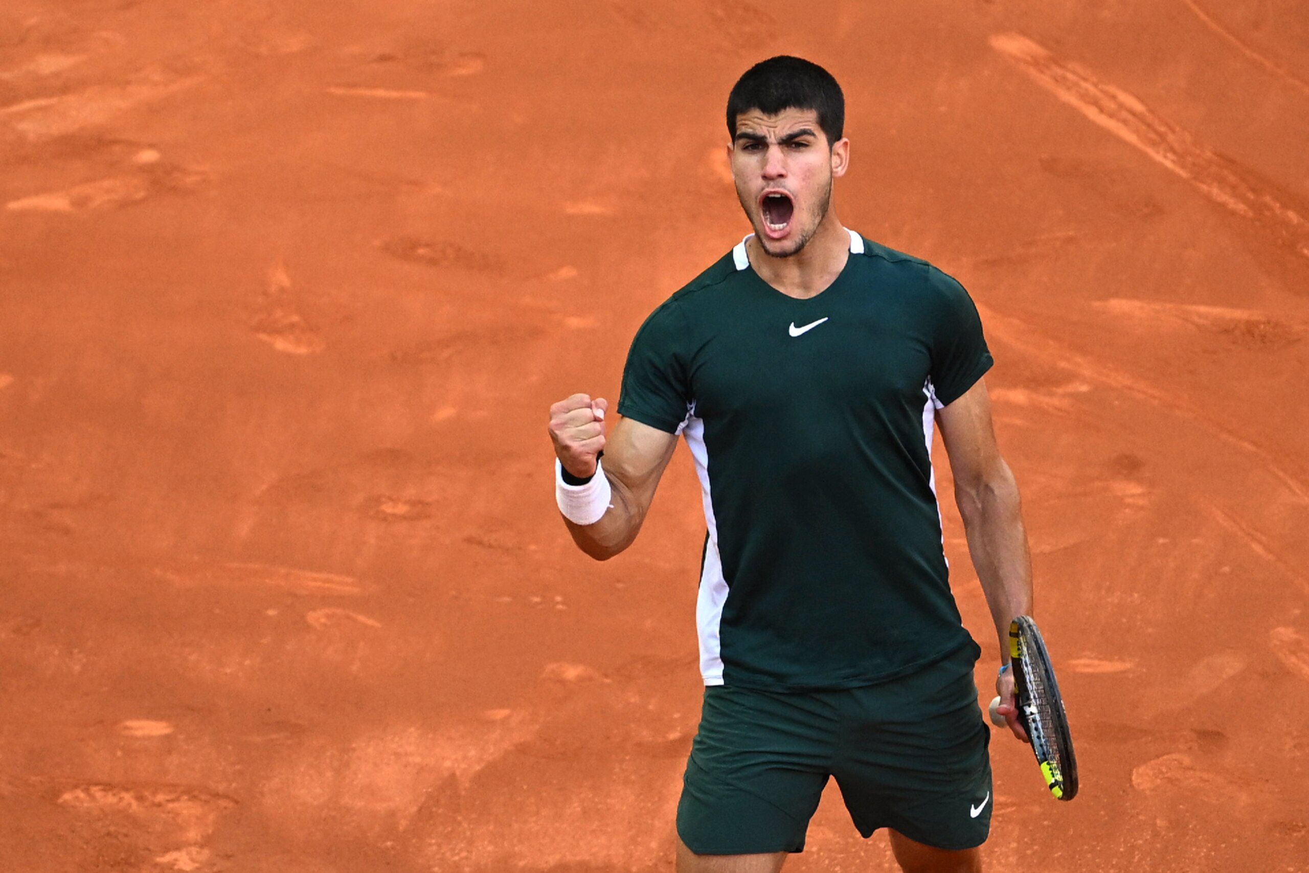 Spain's Carlos Alcaraz reacts as he plays against Serbia's Novak Djokovic during their 2022 ATP Tour Madrid Open tennis tournament men's singles semi-final match at the Caja Magica in Madrid on May 7, 2022. (Photo by GABRIEL BOUYS / AFP) (Photo by GABRIEL BOUYS/AFP via Getty Images)