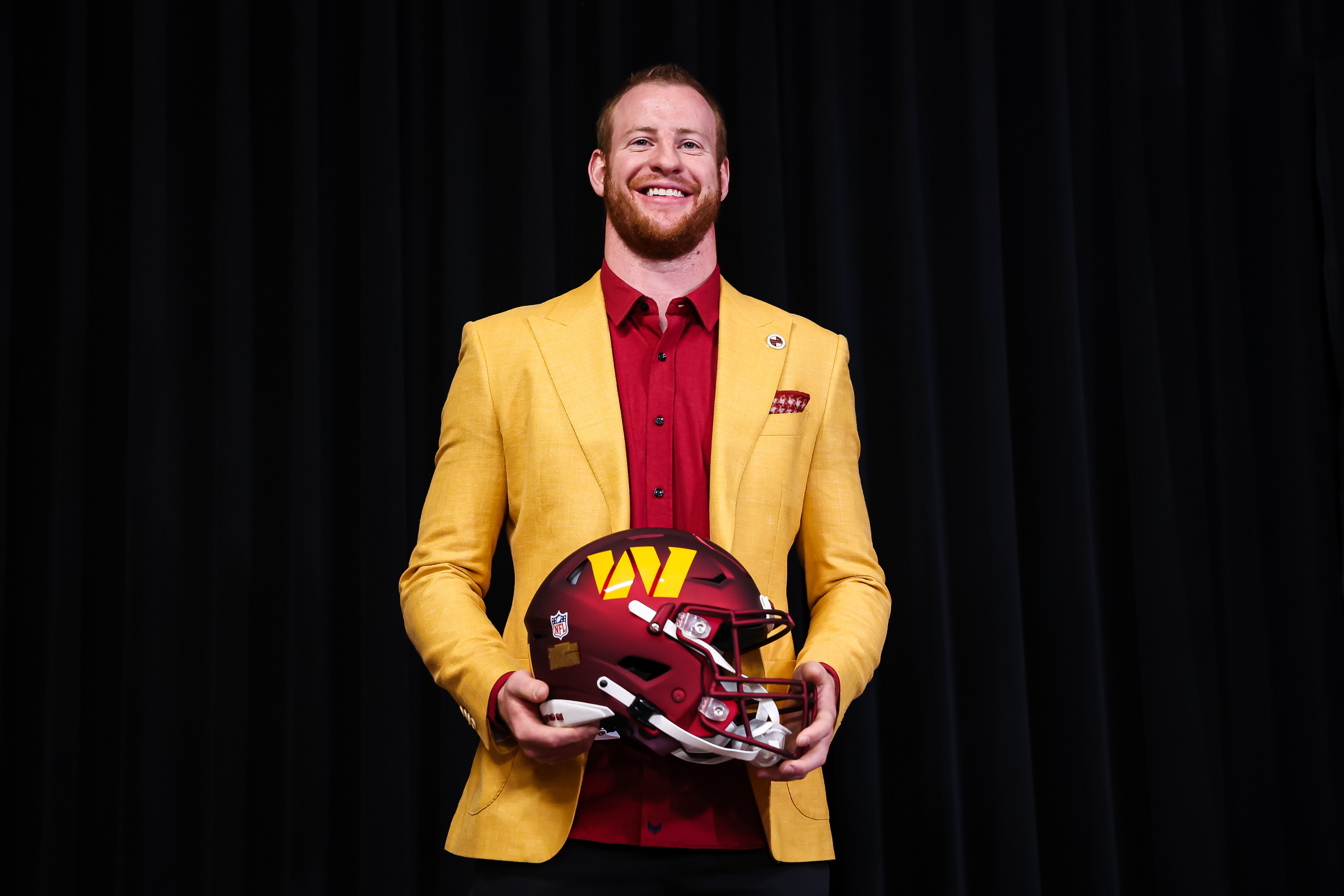 ASHBURN, VA - MARCH 17: Quarterback Carson Wentz of the Washington Commanders stands with a helmet after being introduced at Inova Sports Performance Center on March 17, 2022 in Ashburn, Virginia. (Photo by Scott Taetsch/Getty Images)