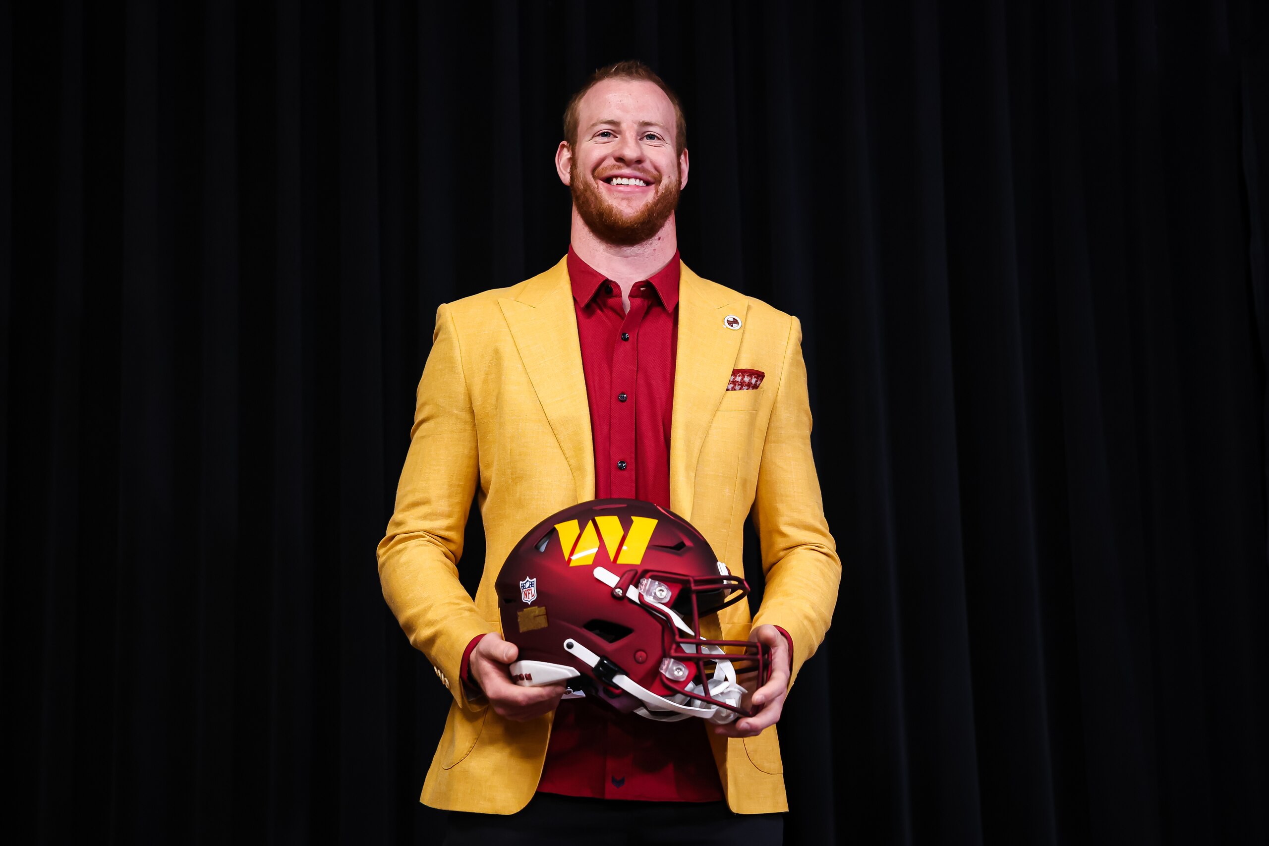 ASHBURN, VA - MARCH 17: Quarterback Carson Wentz of the Washington Commanders stands with a helmet after being introduced at Inova Sports Performance Center on March 17, 2022 in Ashburn, Virginia. (Photo by Scott Taetsch/Getty Images)