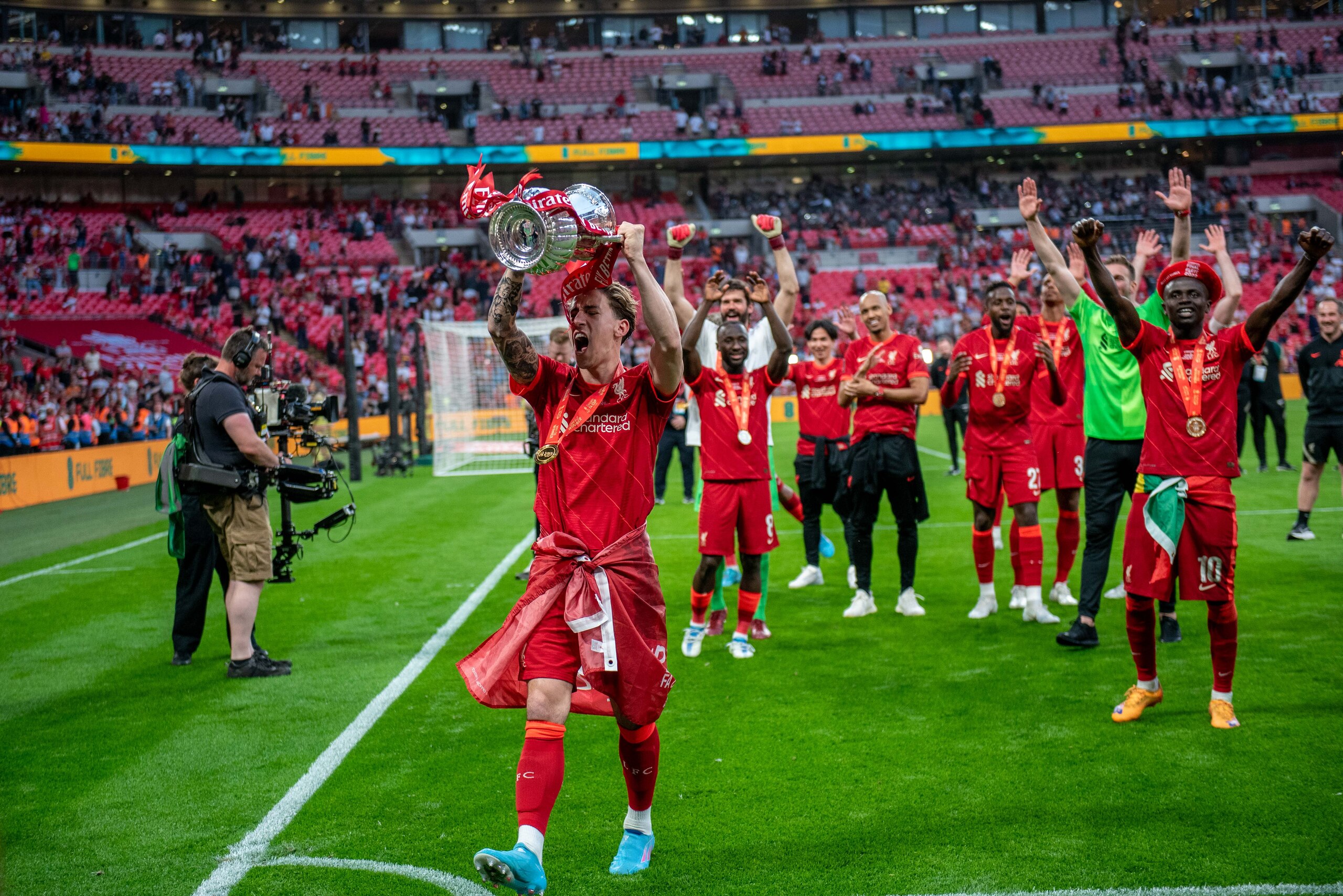 LONDON, ENGLAND - MAY 14: Kostas Tsimikas of Liverpool celebrates and lift a trophy after winning a The FA Cup Final match between Chelsea and Liverpool at Wembley Stadium on May 14, 2022 in London, England. (Photo by Sebastian Frej/MB Media/Getty Images)