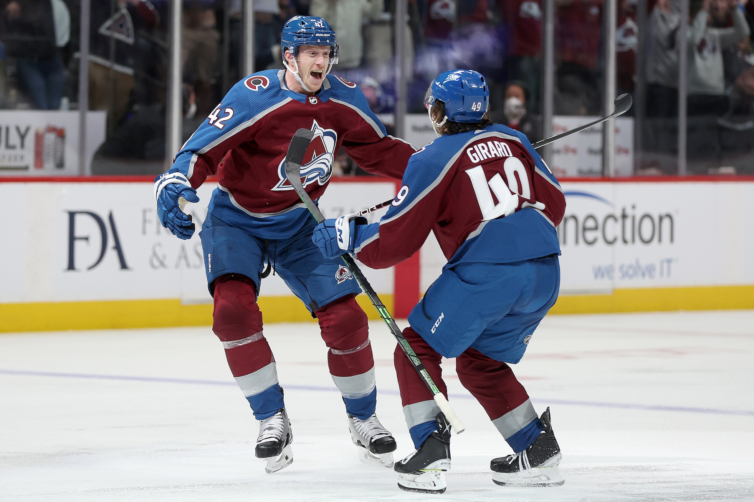 DENVER, COLORADO - MAY 17: Josh Manson #42 of the Colorado Avalanche celebrates with Samuel Girard #49 after scoring the winning goal against the St Louis Blues in overtime during Game One of the Second Round of the 2022 Stanley Cup Playoffs at Ball Arena on May 17, 2022 in Denver, Colorado. (Photo by Matthew Stockman/Getty Images)