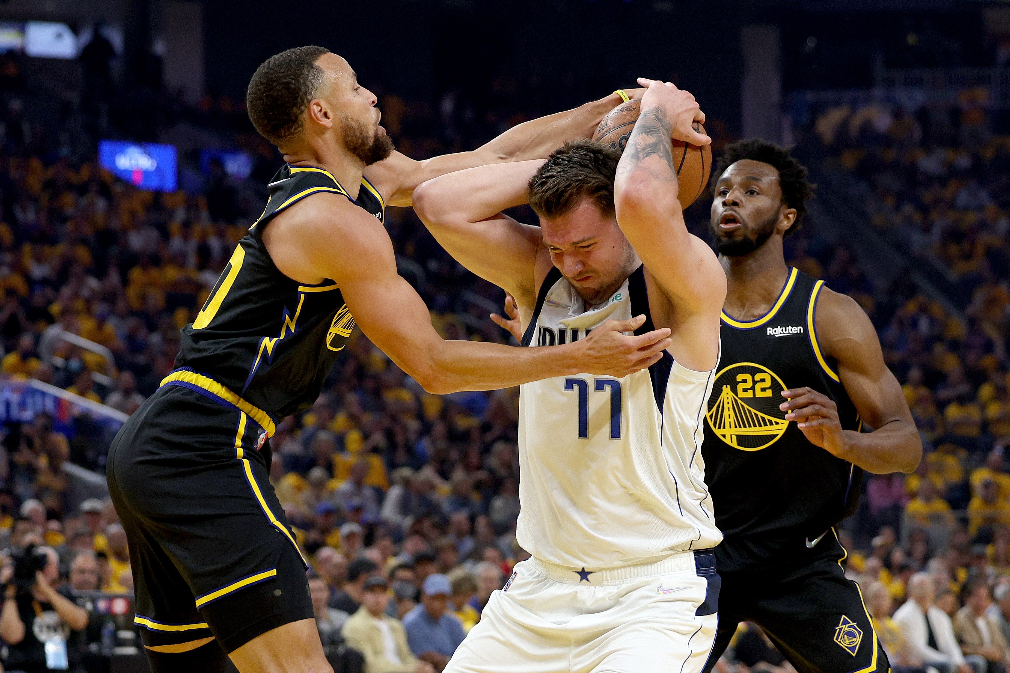 SAN FRANCISCO, CALIFORNIA - MAY 18: Luka Doncic #77 of the Dallas Mavericks and Stephen Curry #30 of the Golden State Warriors fight for the ball during the first quarter in Game One of the 2022 NBA Playoffs Western Conference Finals at Chase Center on May 18, 2022 in San Francisco, California. NOTE TO USER: User expressly acknowledges and agrees that, by downloading and or using this photograph, User is consenting to the terms and conditions of the Getty Images License Agreement.  (Photo by Harry How/Getty Images)
