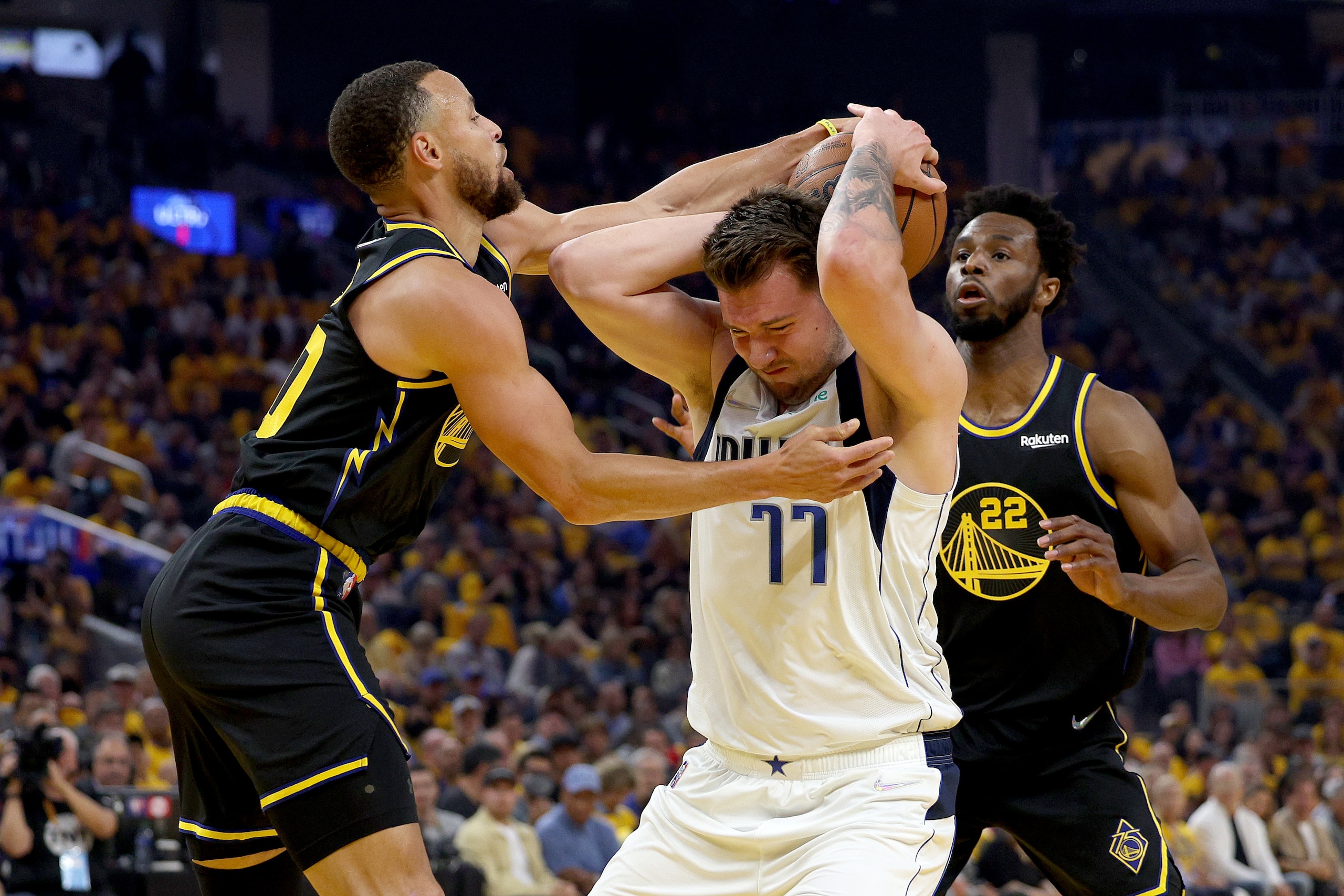SAN FRANCISCO, CALIFORNIA - MAY 18: Luka Doncic #77 of the Dallas Mavericks and Stephen Curry #30 of the Golden State Warriors fight for the ball during the first quarter in Game One of the 2022 NBA Playoffs Western Conference Finals at Chase Center on May 18, 2022 in San Francisco, California. NOTE TO USER: User expressly acknowledges and agrees that, by downloading and or using this photograph, User is consenting to the terms and conditions of the Getty Images License Agreement.  (Photo by Harry How/Getty Images)