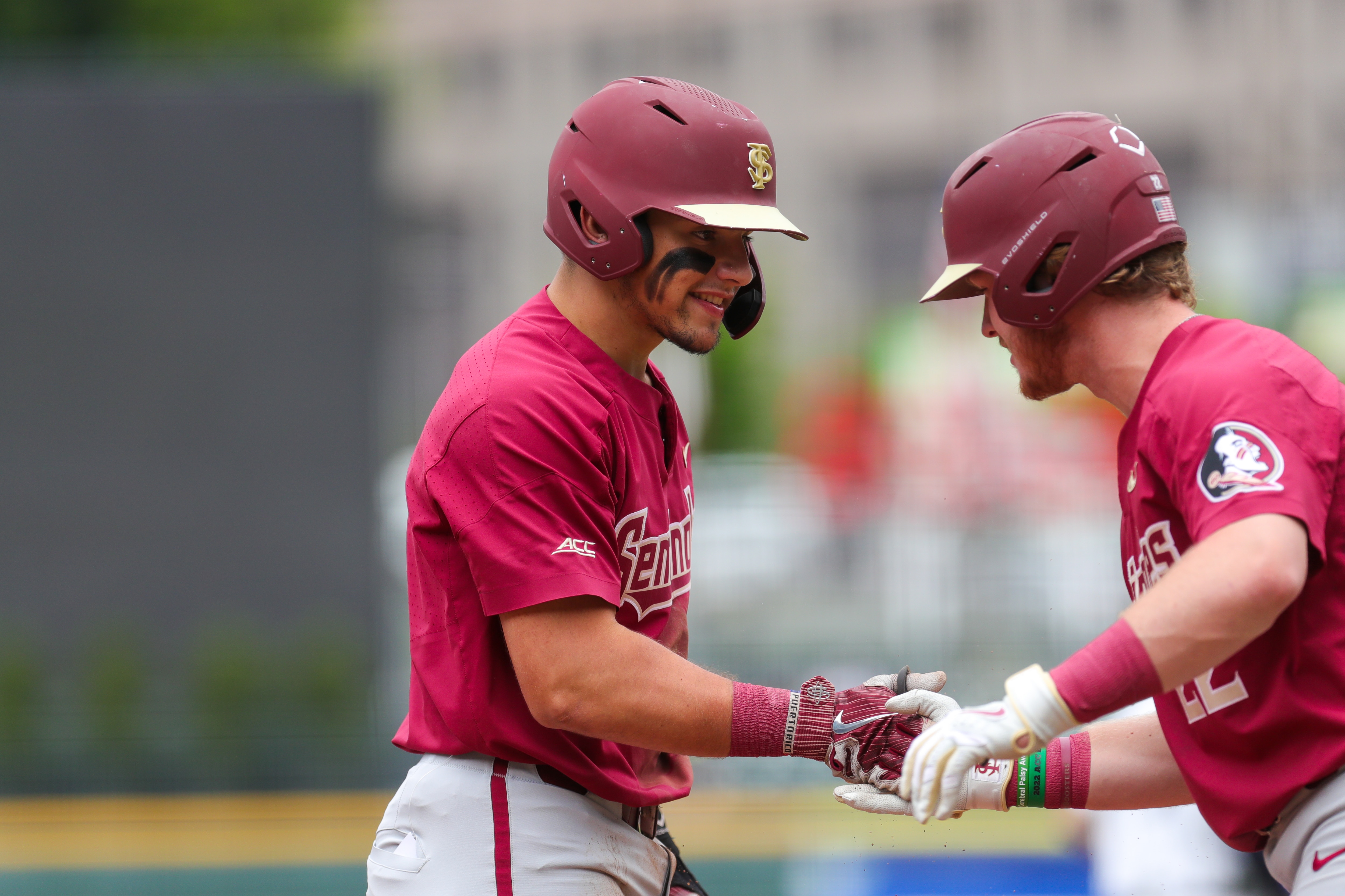 CHARLOTTE, NC - MAY 25: James Tibbs (22) of the Florida St. Seminoles gives Jaime Ferrer (7) a high five after scoring a run during the ACC Baseball Championship Tournament between the Florida St. Seminoles and the Virginia Cavaliers on May 25, 2022, at Truist Field in Charlotte, NC.  (Photo by David Jensen/Icon Sportswire via Getty Images)