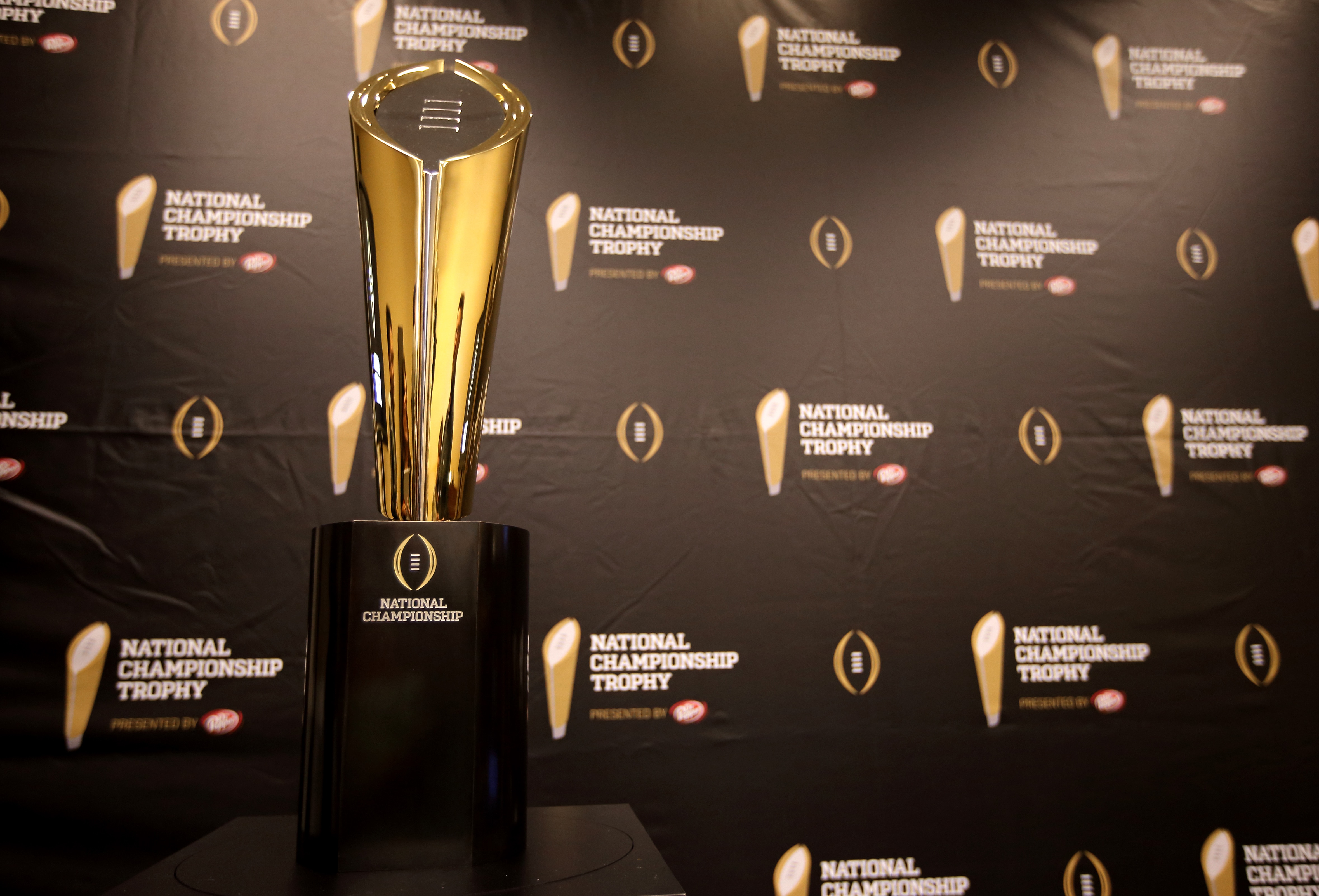 This Monday, July 14, 2014 photo shows the College Football Playoff National Championship Trophy in Irving, Texas. A rising gold football-shaped trophy will be the prize for the national champion in the new College Football Playoff. (AP Photo/Tony Gutierrez)