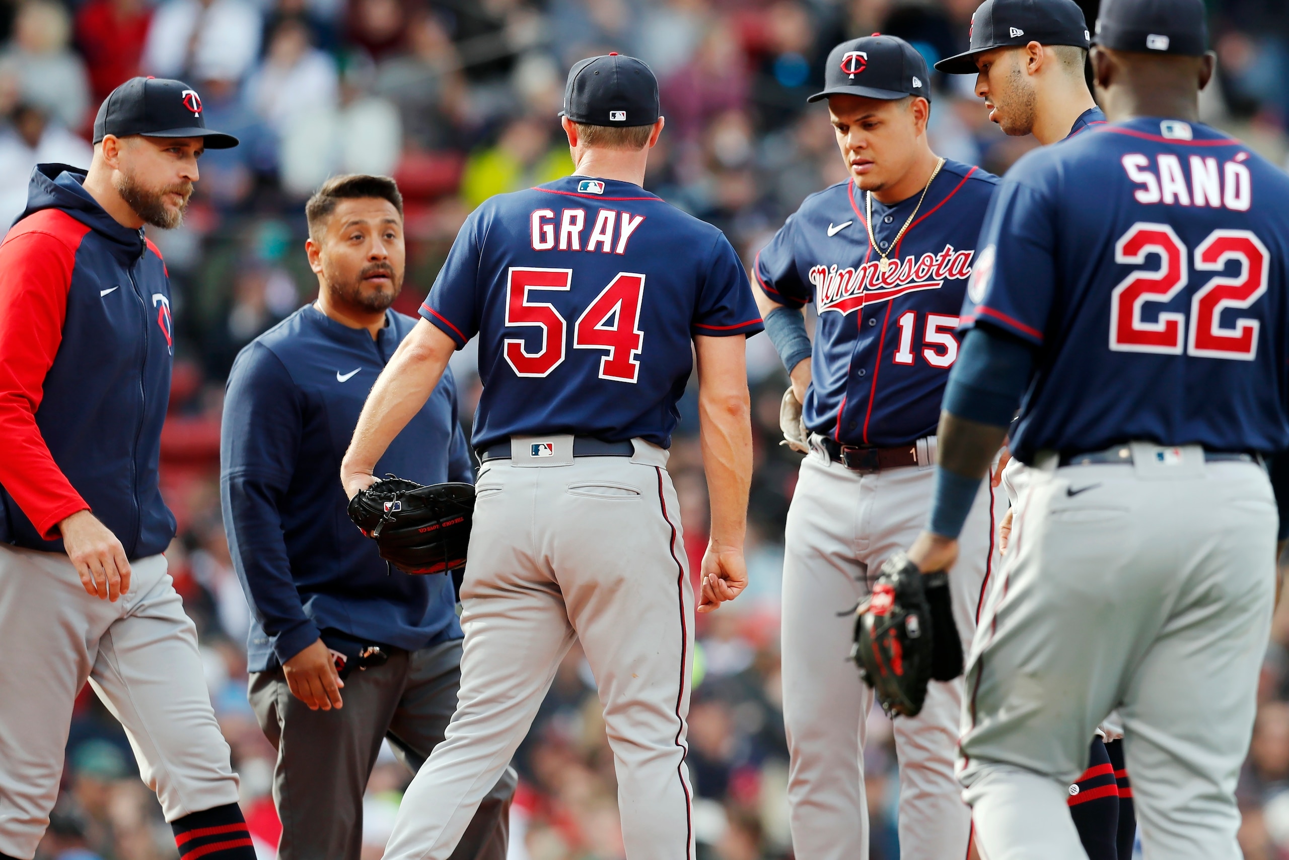 Minnesota Twins manager Rocco Baldelli, left, comes to the mound with a trainer to talk with Sonny Gray (54) during the second inning of a baseball game against the Boston Red Sox, Saturday, April 16, 2022, in Boston. Gray left the game. (AP Photo/Michael Dwyer)