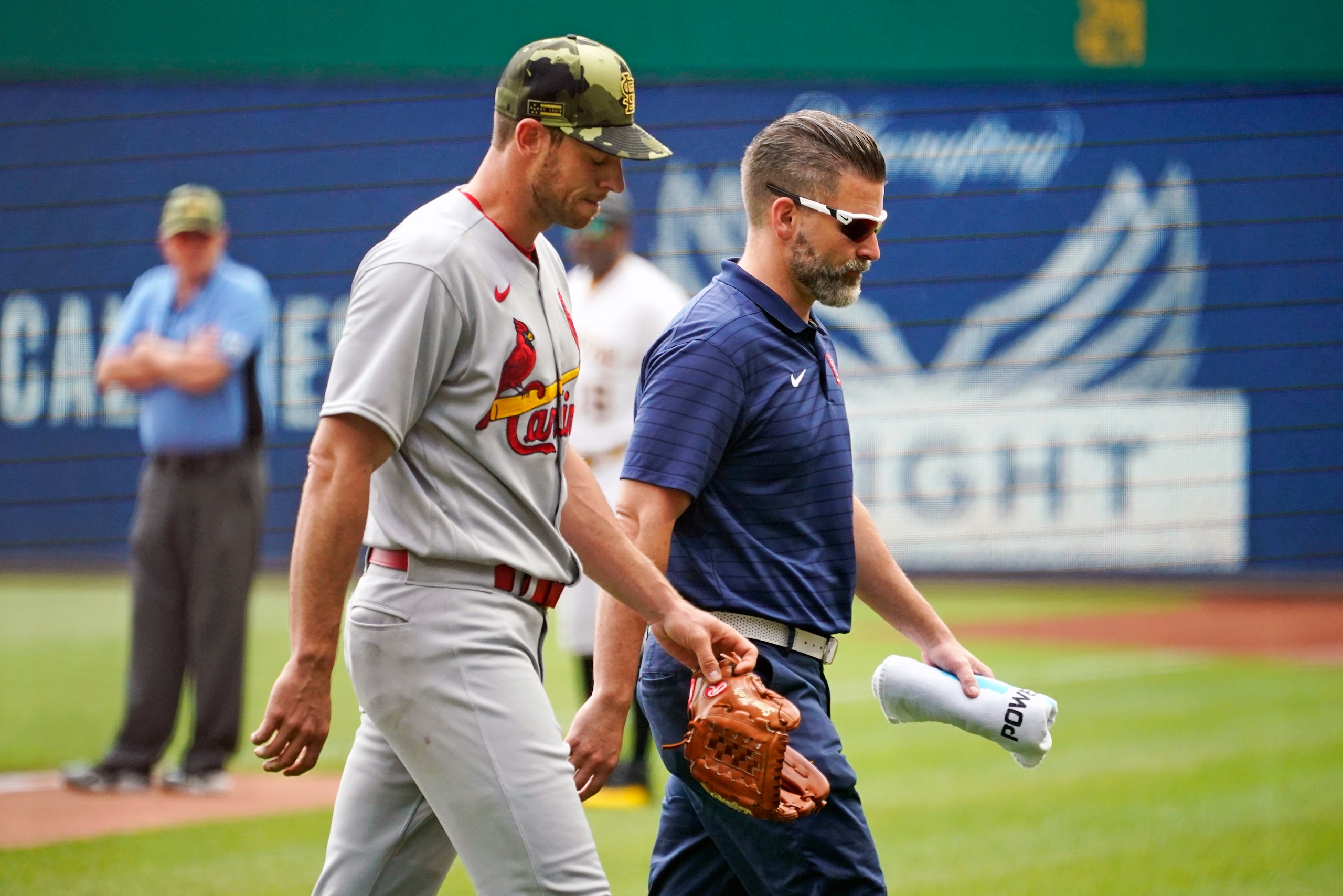 St. Louis Cardinals starting pitcher Steven Matz, left, walks to the dugout with a team trainer after facing one batter during the first inning of a baseball game against the Pittsburgh Pirates in Pittsburgh, Sunday, May 22, 2022. (AP Photo/Gene J. Puskar)
