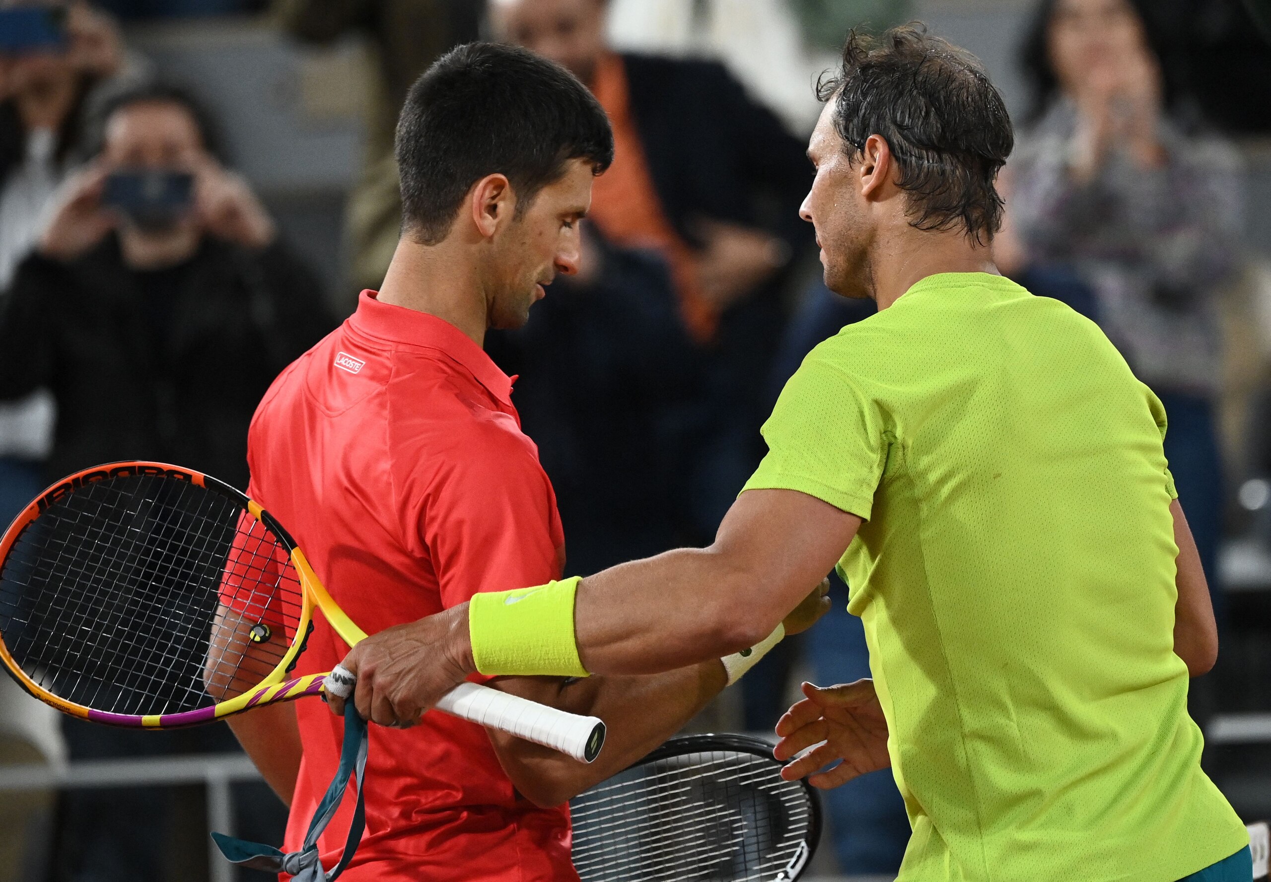 Spain's Rafael Nadal (R) shakes hands with Serbia's Novak Djokovic (L) after winning at the end of their men's singles match on day ten of the Roland-Garros Open tennis tournament at the Court Philippe-Chatrier in Paris early June 1, 2022. (Photo by Anne-Christine POUJOULAT / AFP) (Photo by ANNE-CHRISTINE POUJOULAT/AFP via Getty Images)
