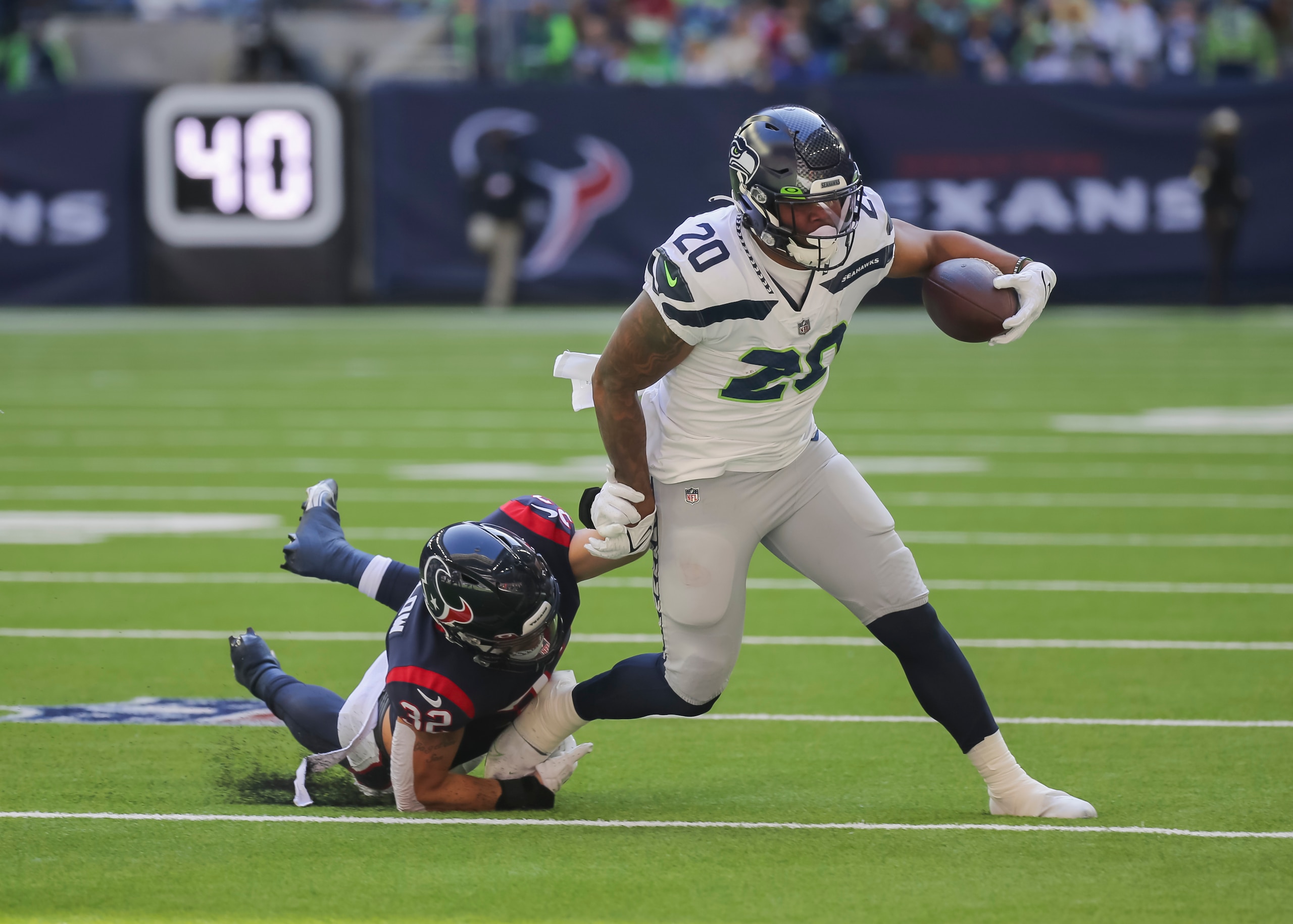 HOUSTON, TX - DECEMBER 12:  Seattle Seahawks running back Rashaad Penny (20) evades a tackle by Houston Texans linebacker Garret Wallow (32) during the NFL football game between the Seattle Seahawks and Houston Texans on December 12, 2021 at NRG Stadium in Houston, Texas.  (Photo by Leslie Plaza Johnson/Icon Sportswire via Getty Images)